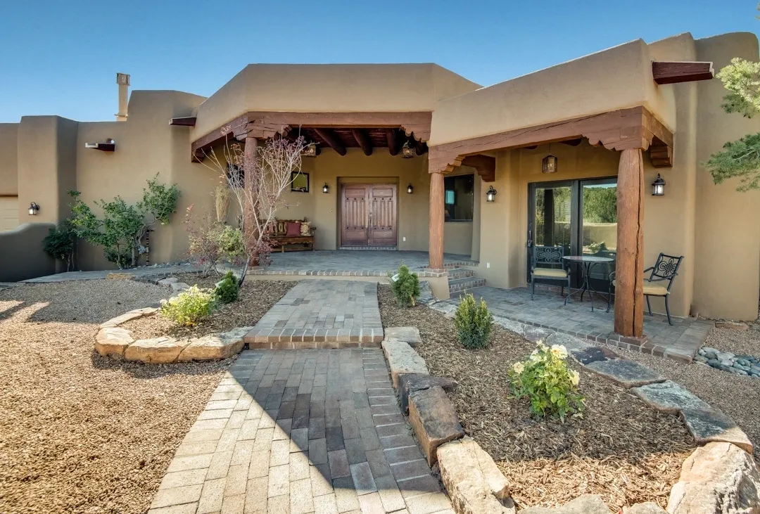 Desert-style house entrance with stone pathway and landscaping.