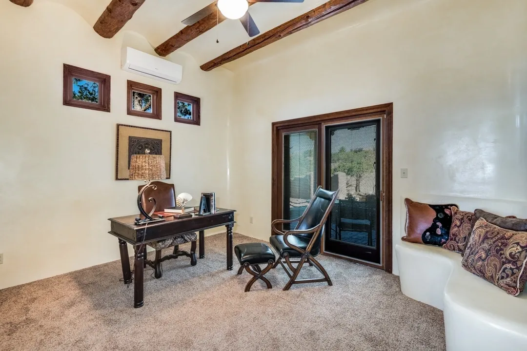 Cozy home office with wooden beams and a leather chair.