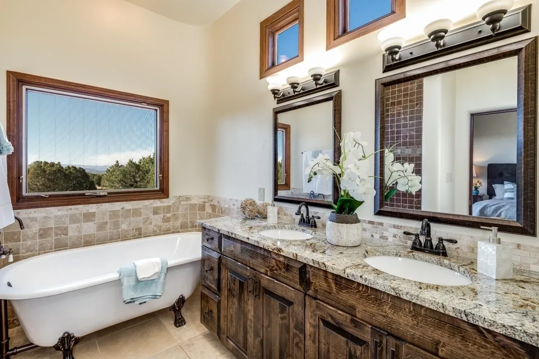 Elegant bathroom with a classic clawfoot tub and granite countertop vanity.