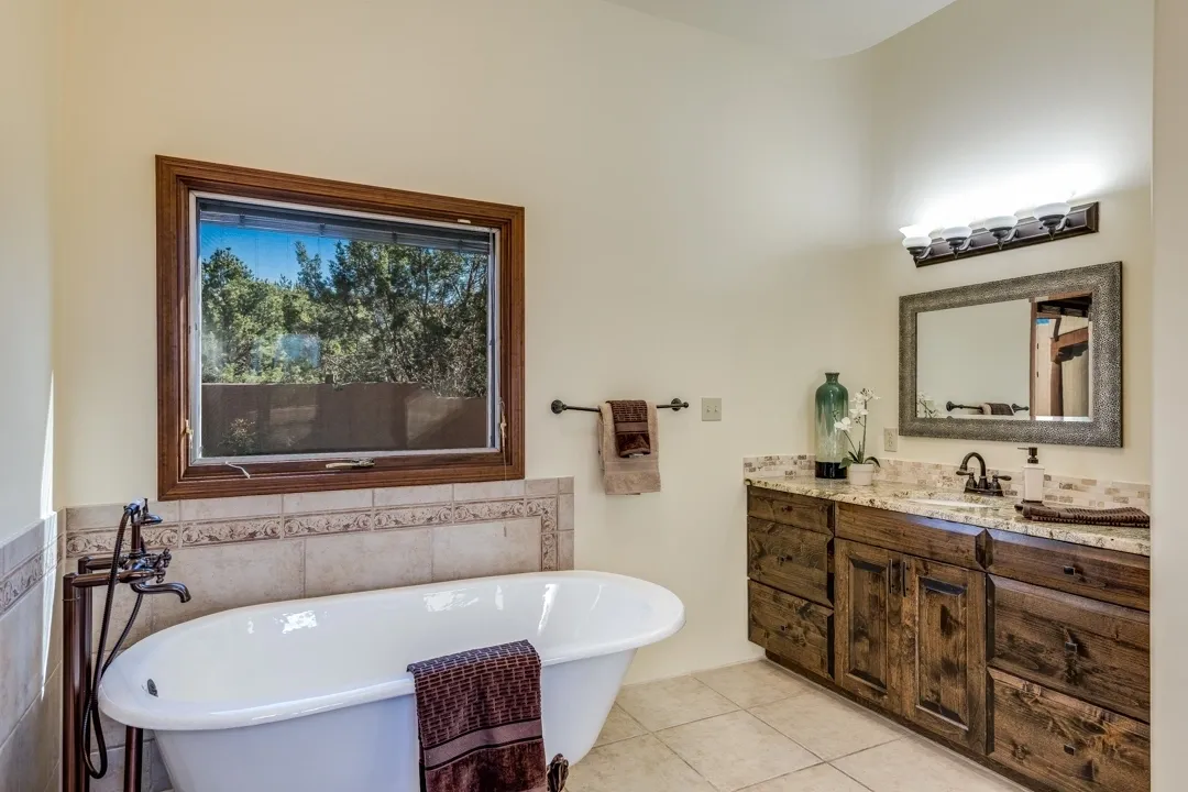 Elegant bathroom with a freestanding tub and rustic wooden vanity.
