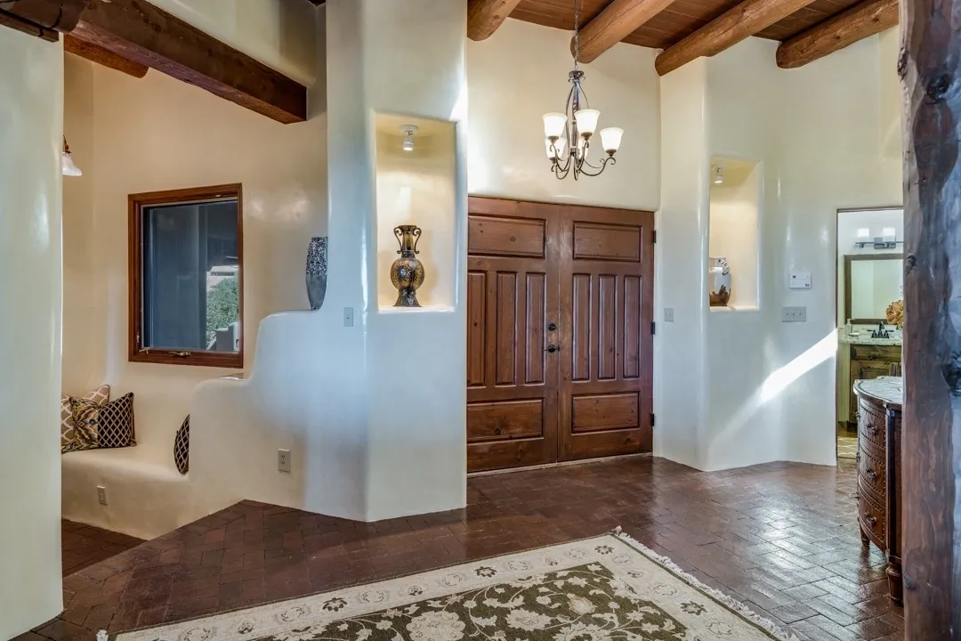 Cozy rustic entryway with wooden door and chandelier.