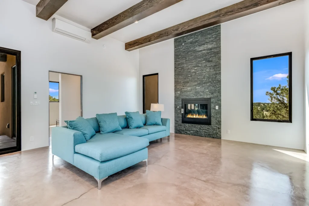 Modern living room with teal sectional sofa and stone fireplace.