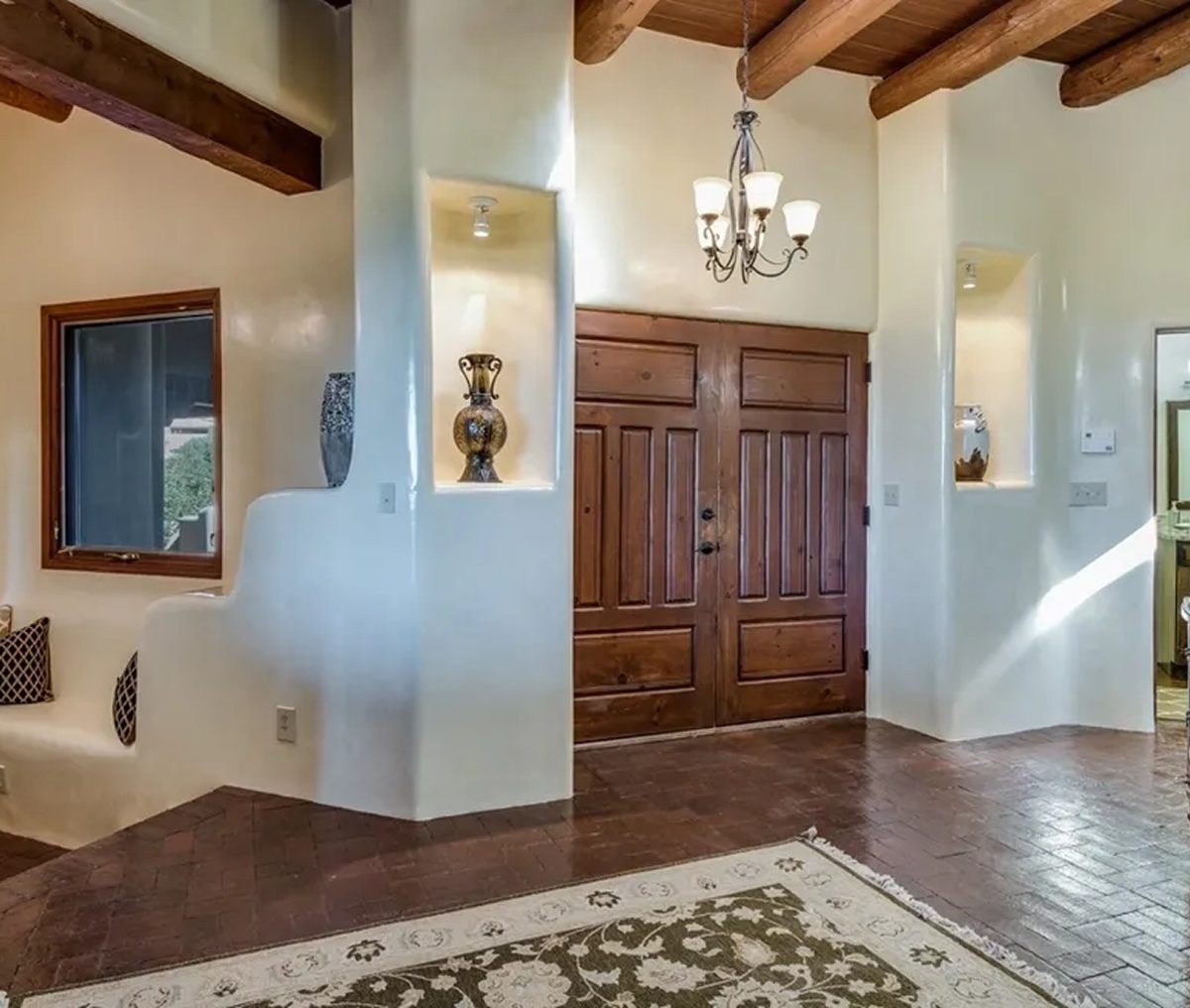 Elegant entryway with wooden double doors and decorative lighting.