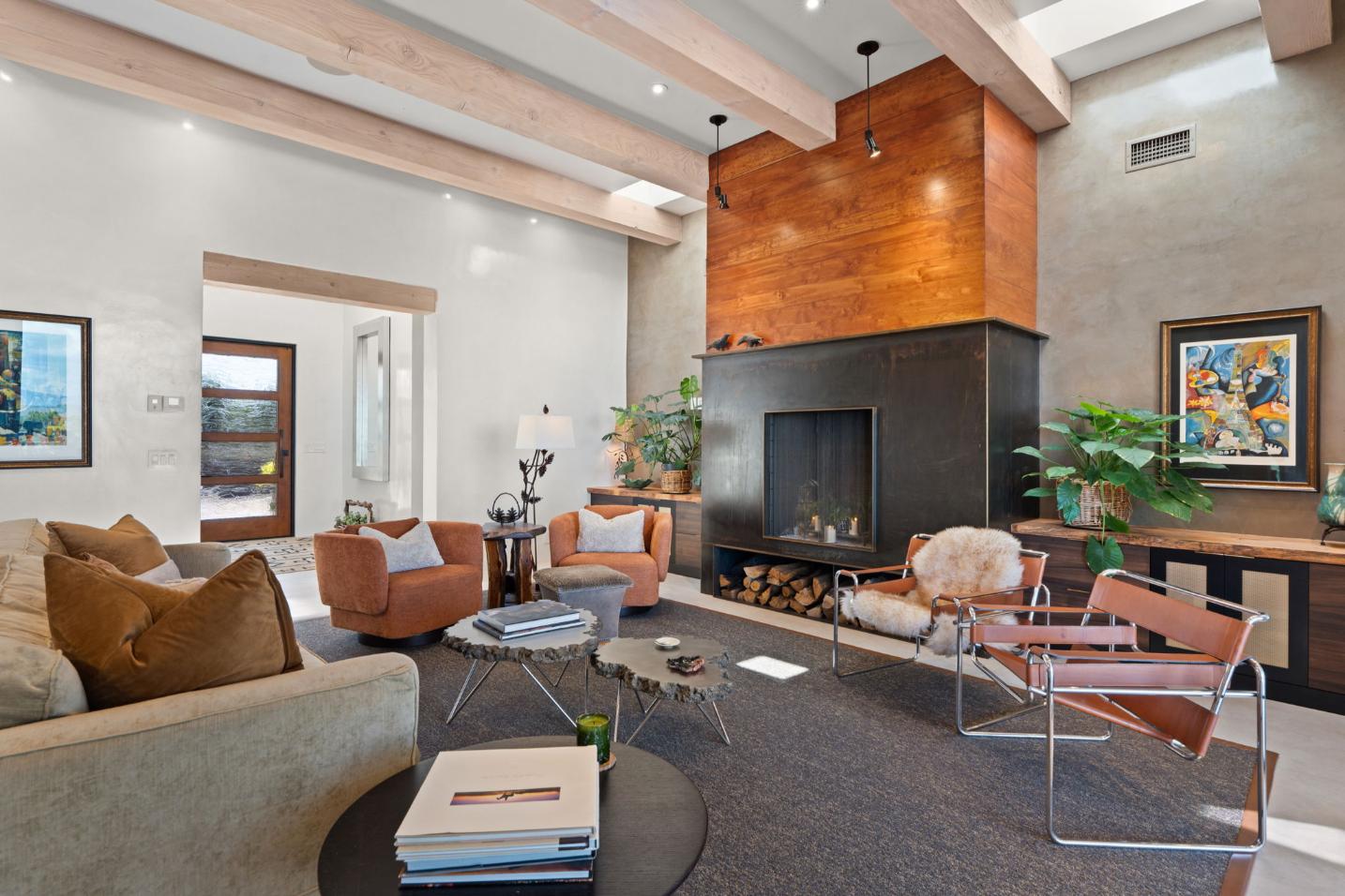 Modern living room with leather chairs and a wooden fireplace.