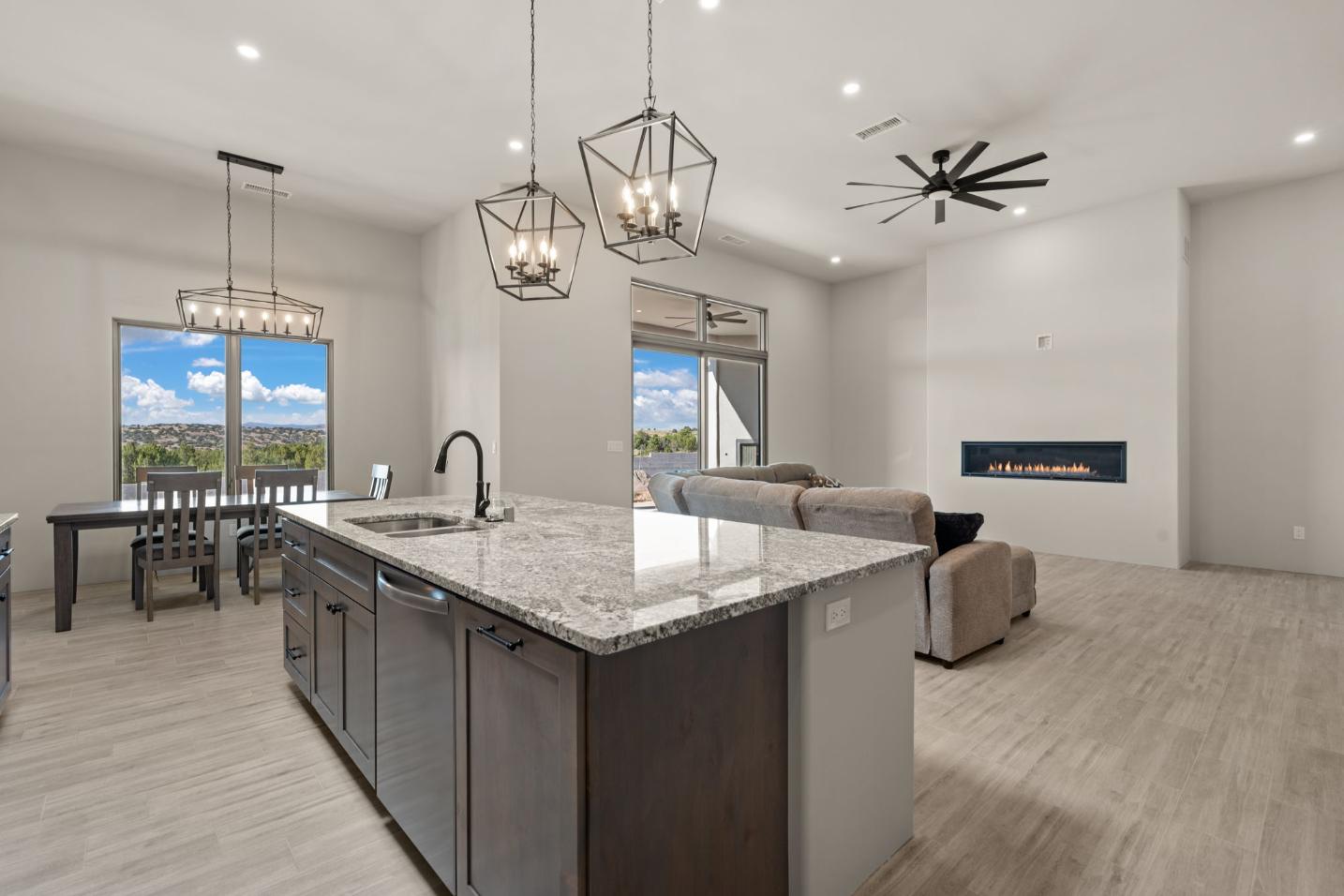 Modern kitchen with marble island and open living area.