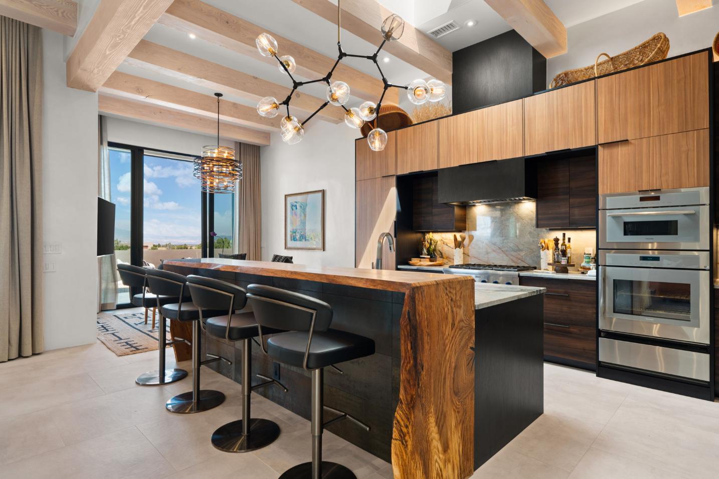 Modern kitchen with wooden island and stylish lighting.