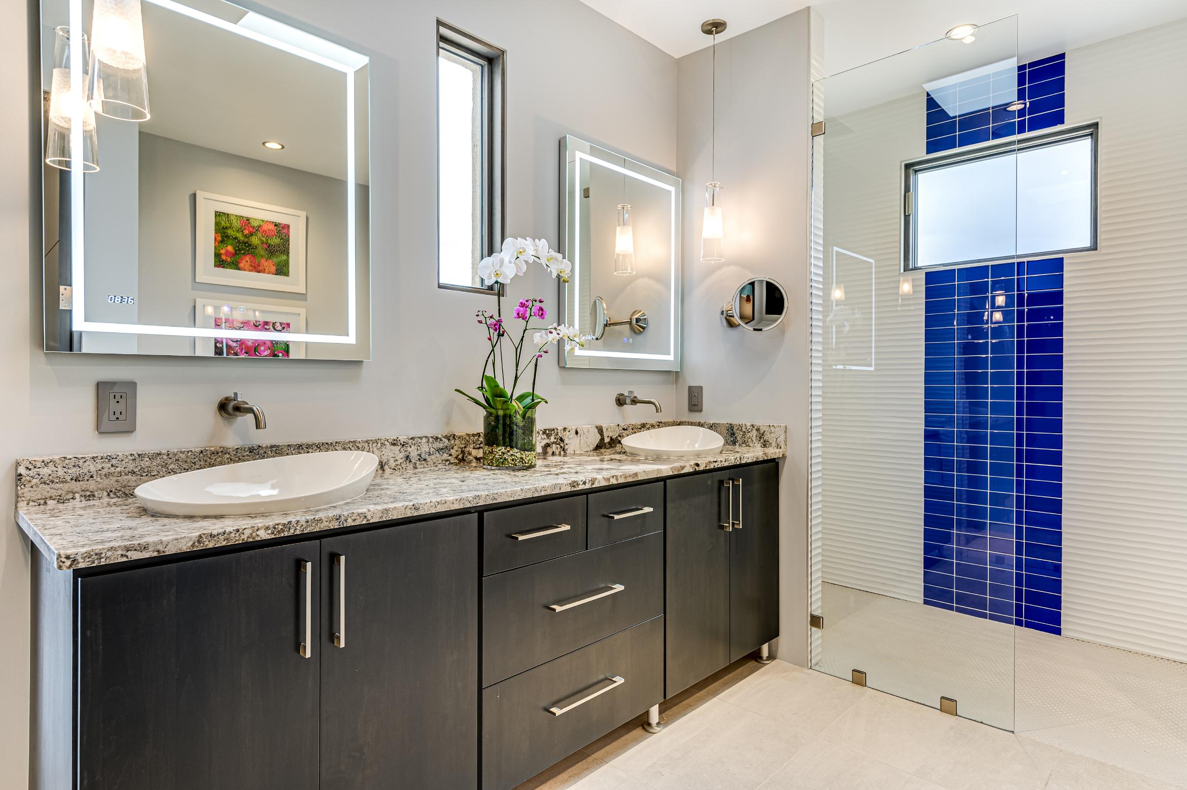 Modern bathroom with granite countertops and dark cabinetry.