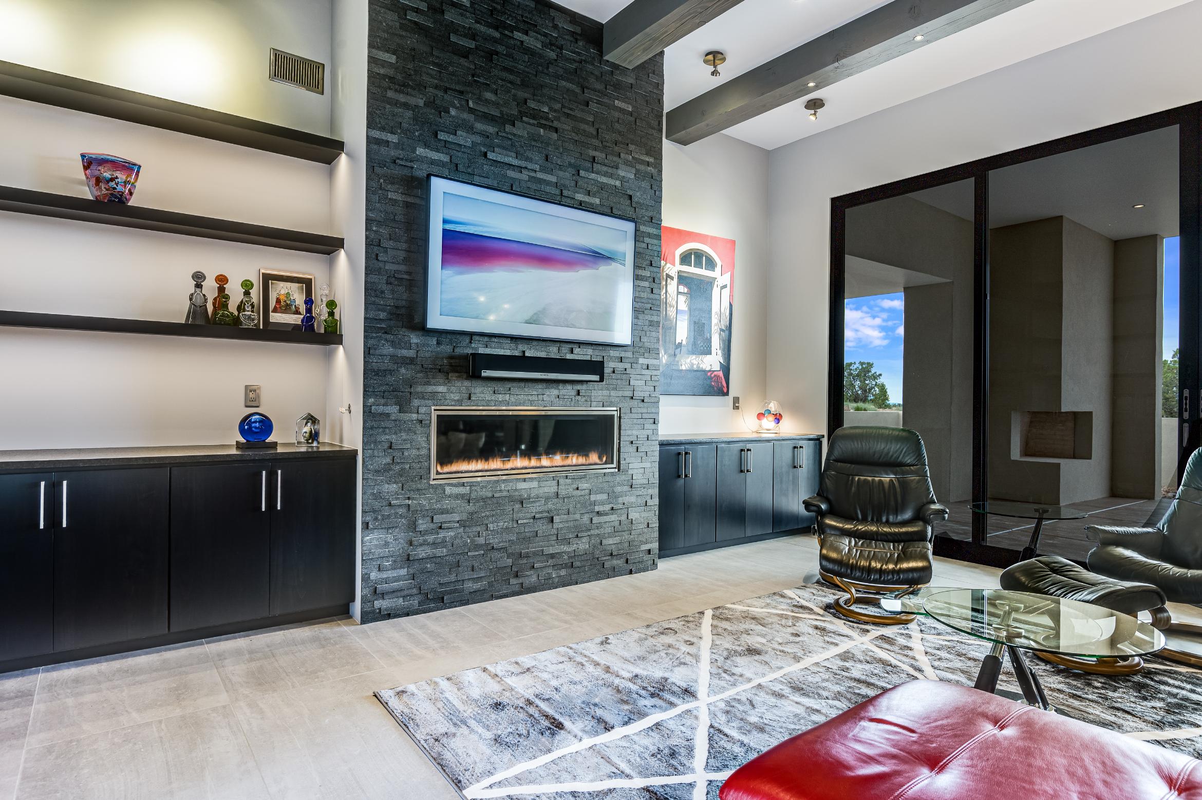 Modern living room with stone fireplace and contemporary decor.