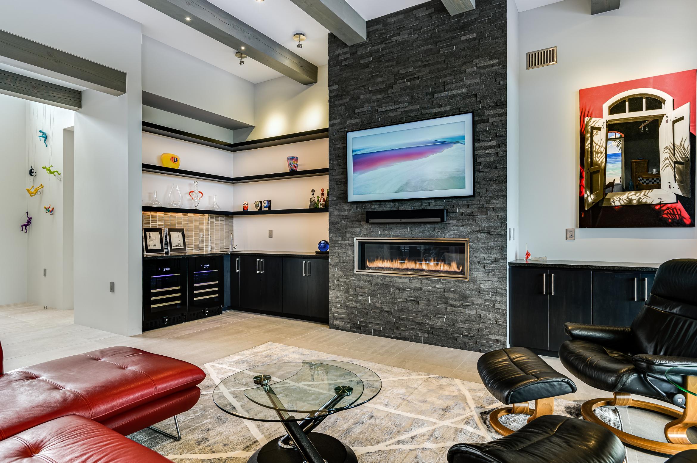 Modern living room with stone fireplace and wall-mounted TV.