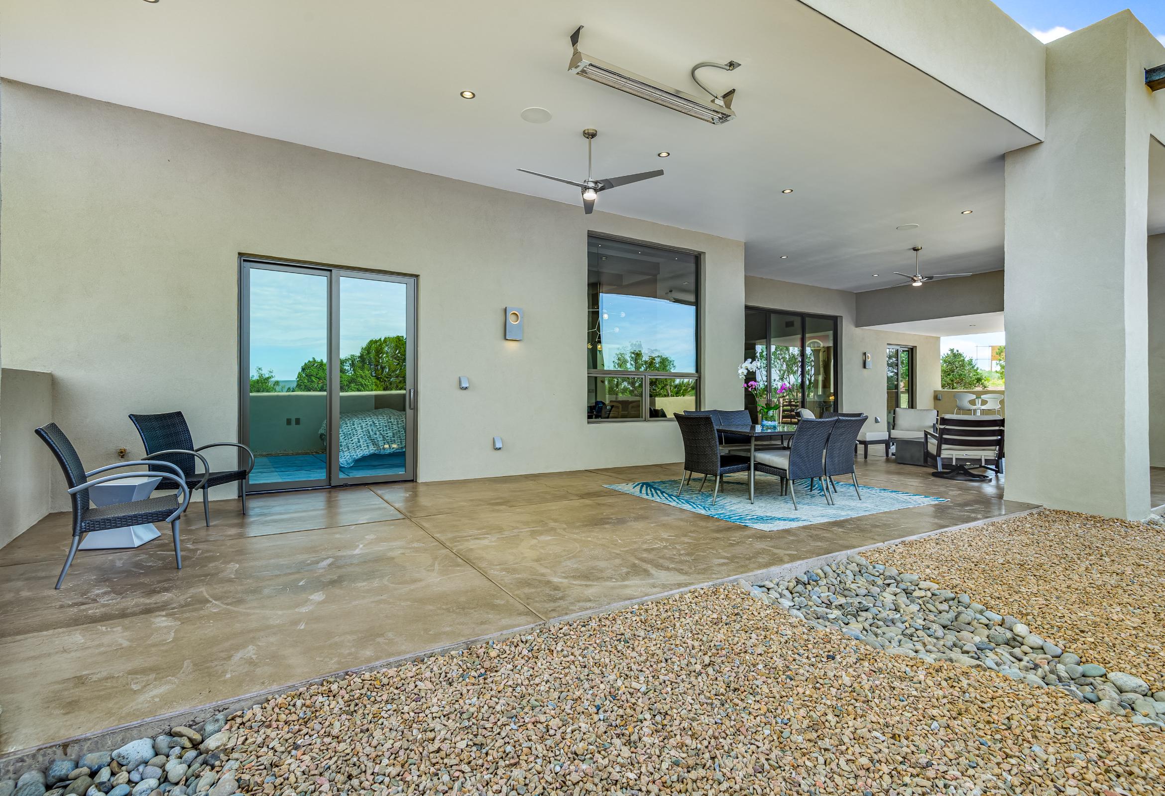 Modern outdoor living space with comfortable seating and ceiling fans.
