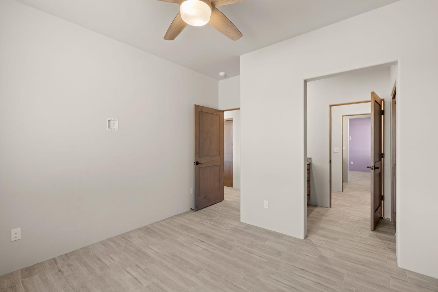 Empty room with light wood flooring and white walls.