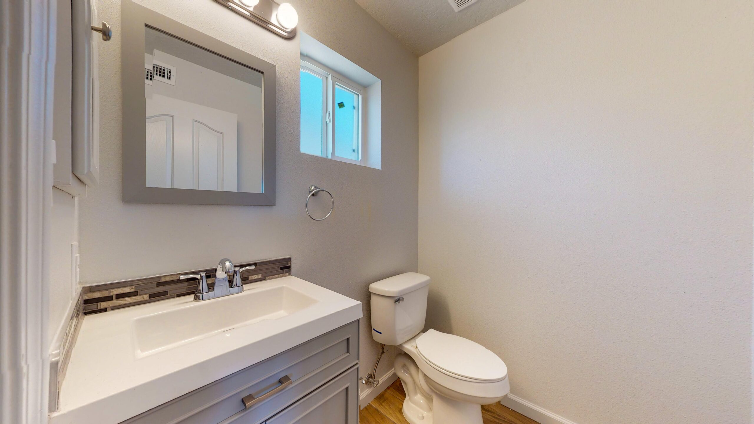 Bright bathroom with white vanity and toilet.