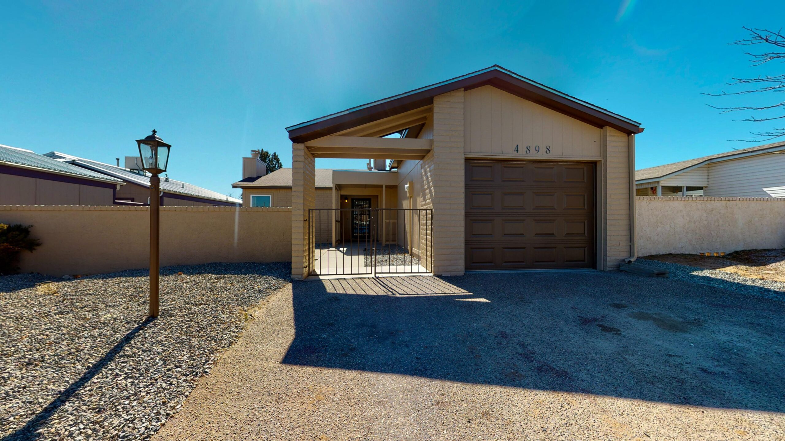 Single-story home with a gated front porch and attached garage.