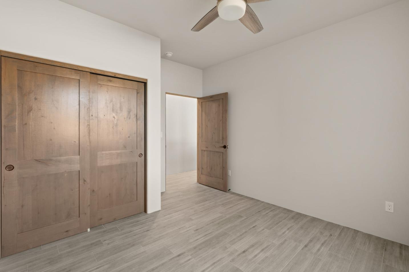 Empty room with wooden doors and light gray flooring.