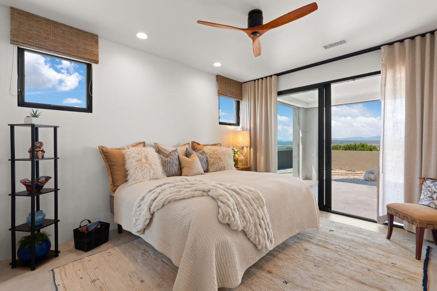 Cozy bedroom with neutral tones and large windows.