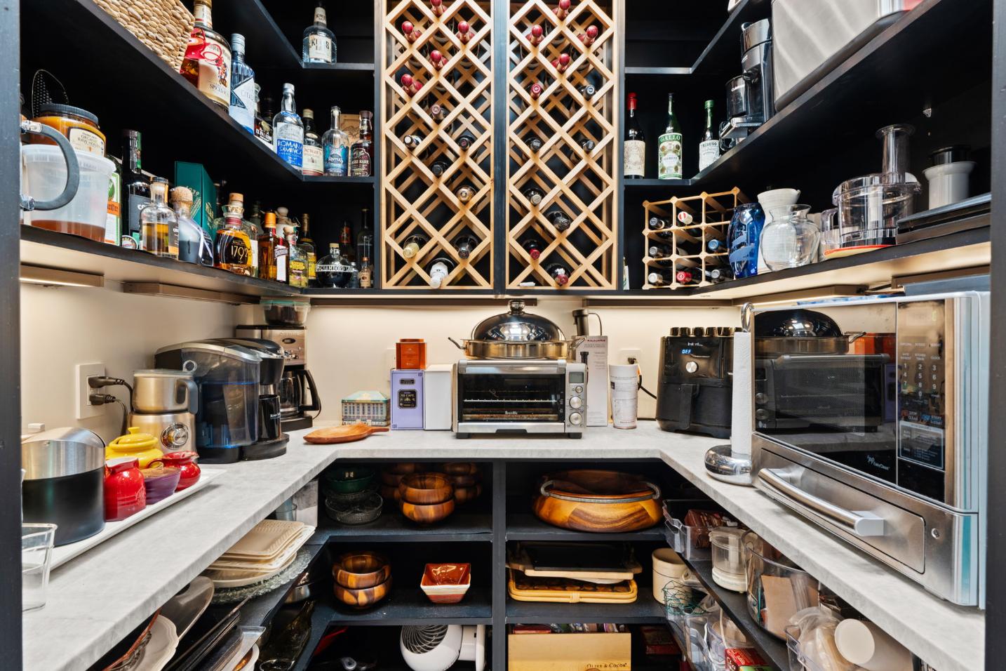 Well-organized pantry with kitchen appliances and food storage.
