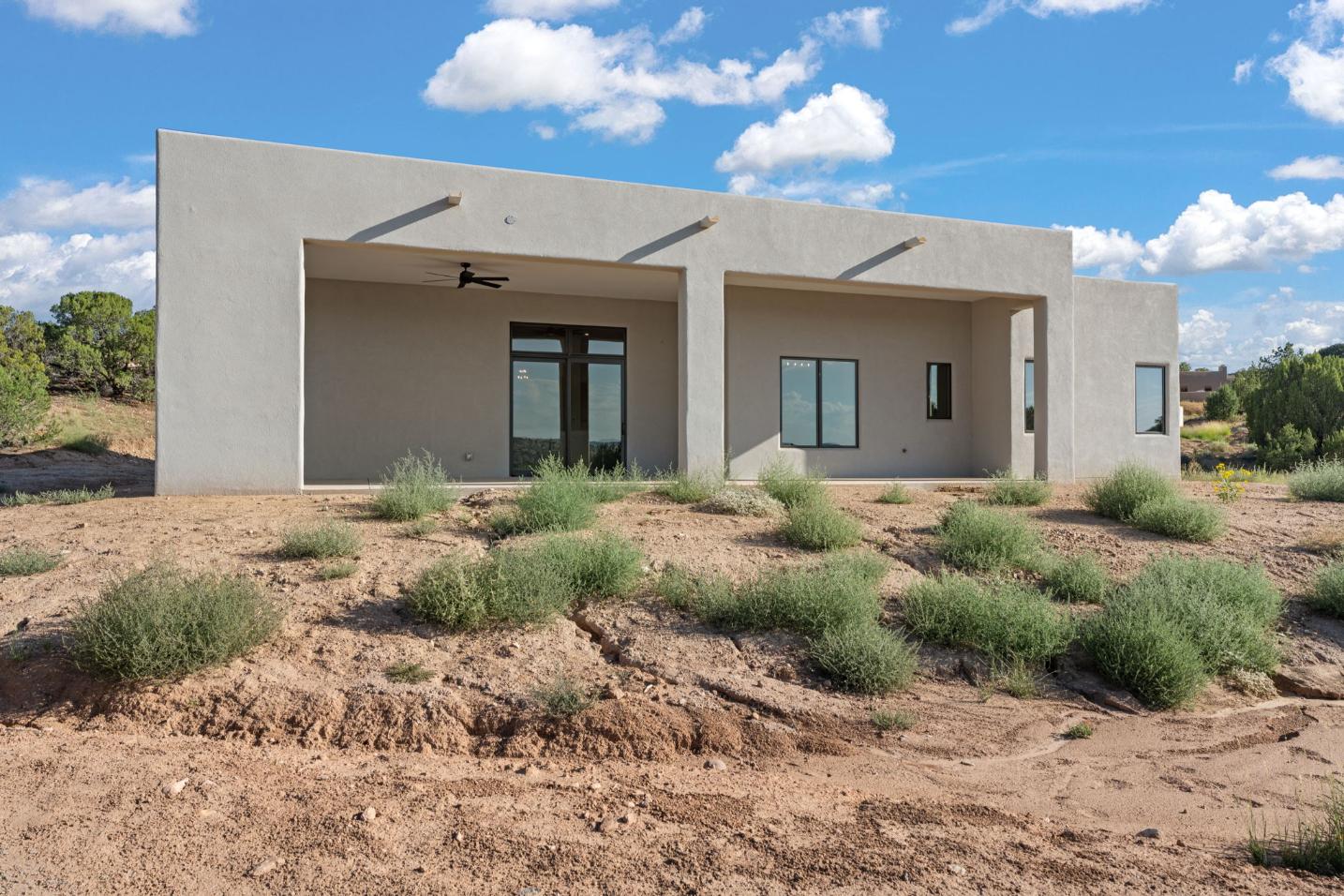 Modern single-story house with a flat roof and desert landscaping.