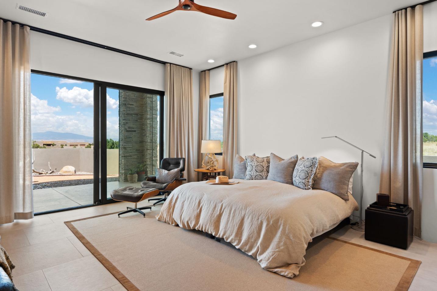 Bright modern bedroom with large bed and sliding glass doors.
