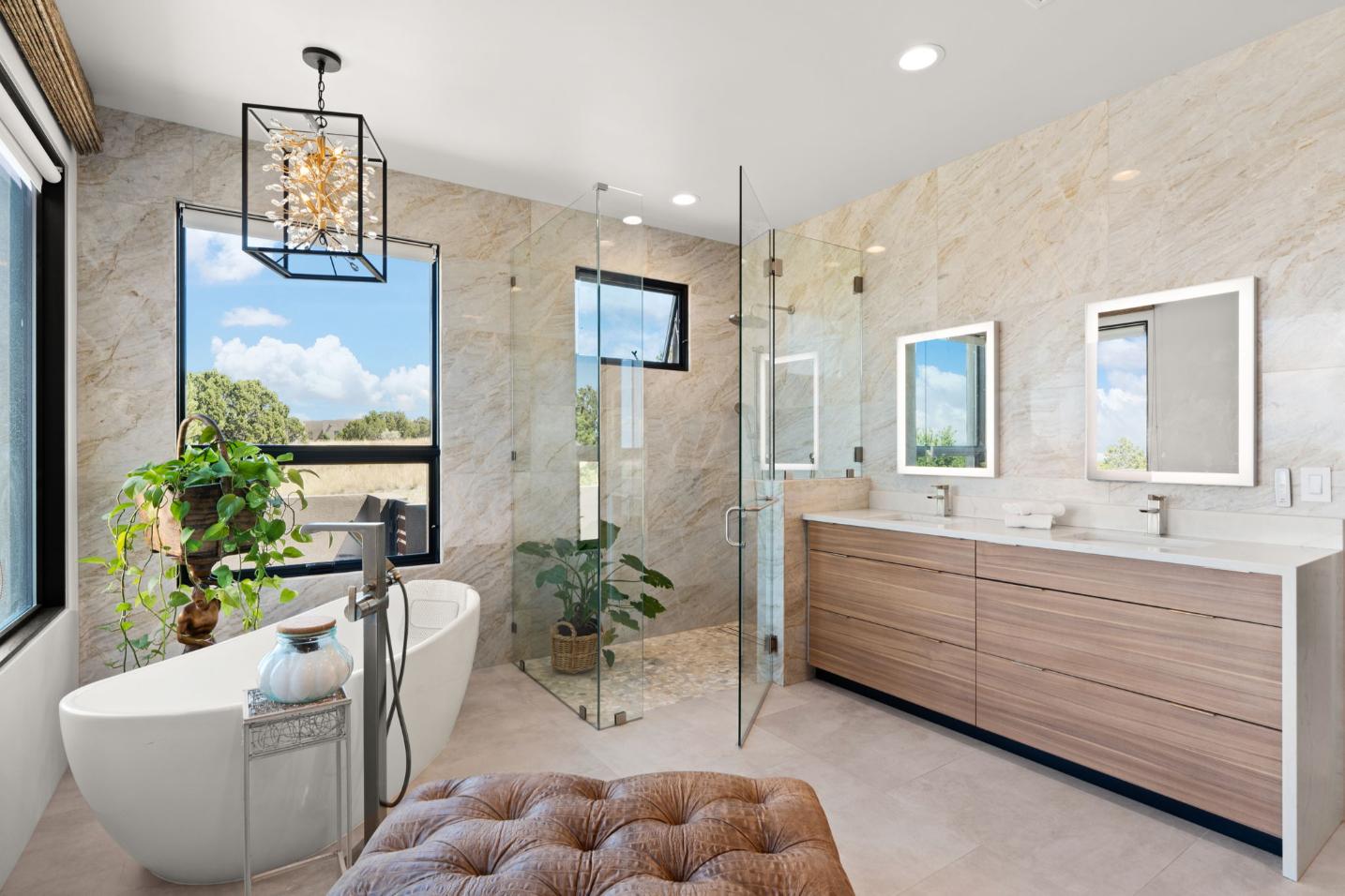 Modern bathroom with glass shower, freestanding tub, and wooden vanity.
