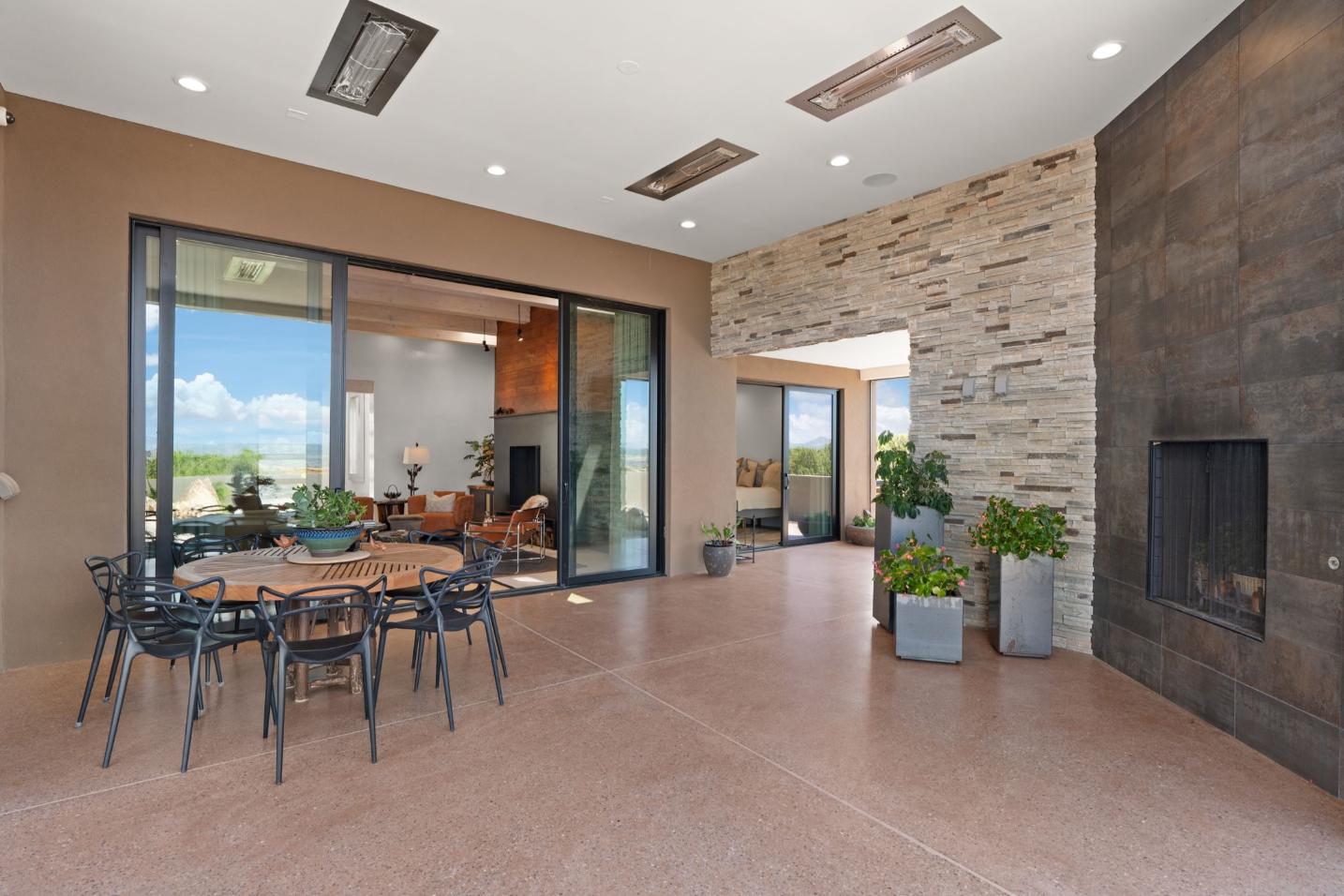 Spacious outdoor patio with dining table and modern stone accent wall.