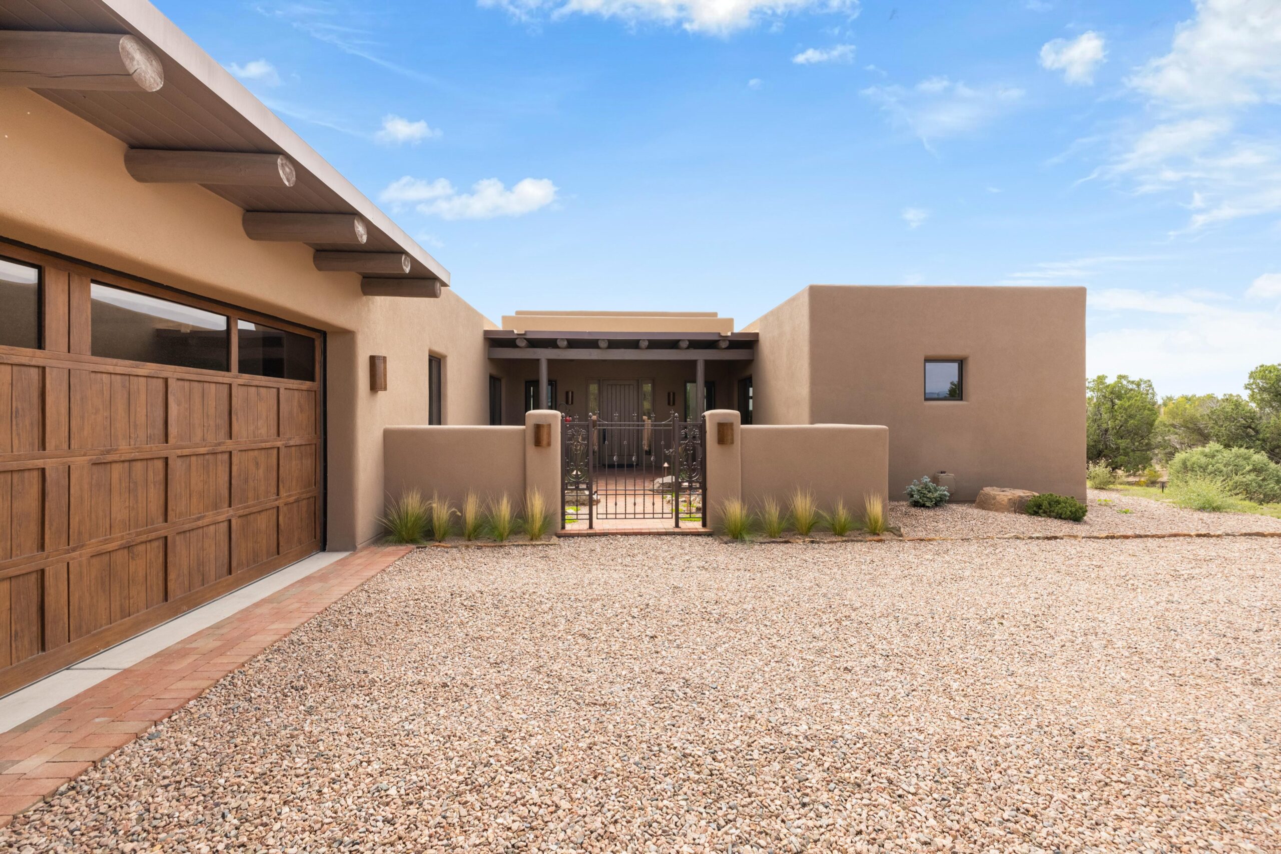 Modern southwestern-style home with a gravel driveway and stucco exterior.