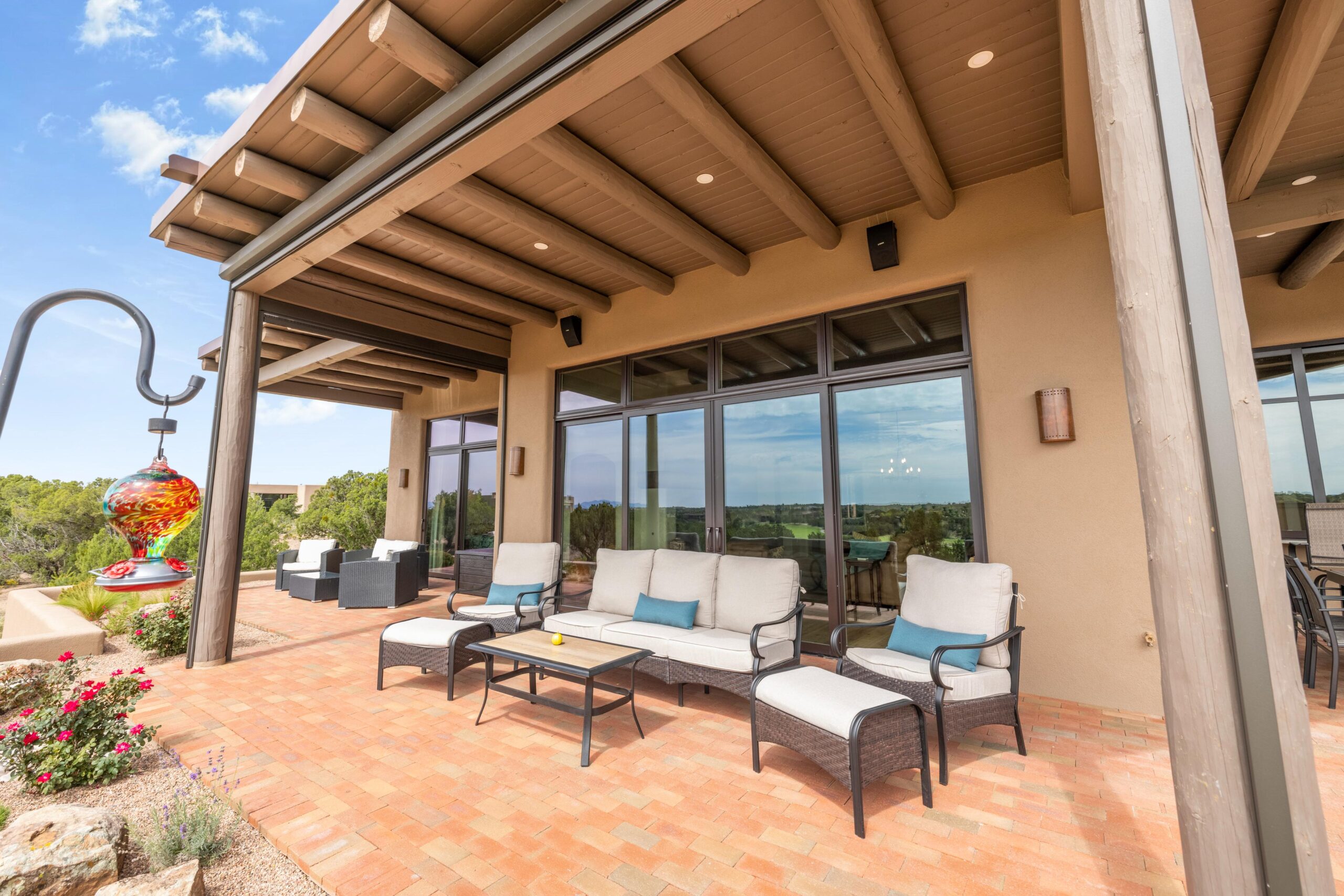Outdoor patio with modern seating and scenic views under a pergola.