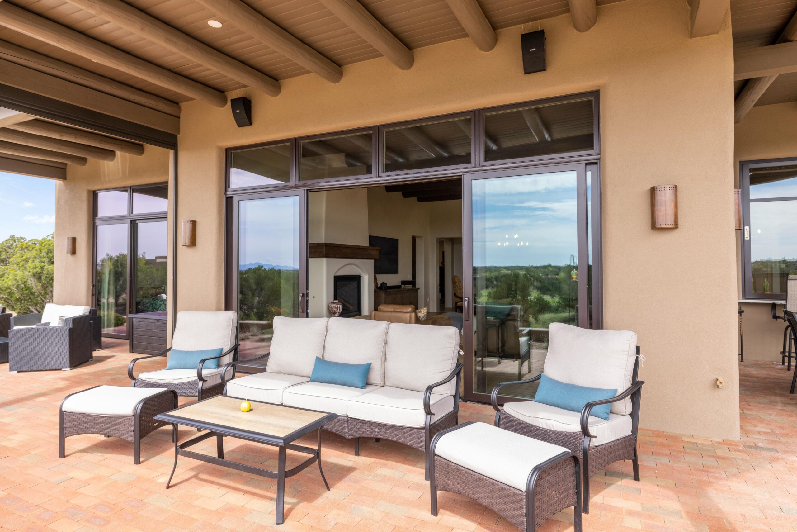 Cozy outdoor seating area with cushioned chairs and a sofa under a covered patio.