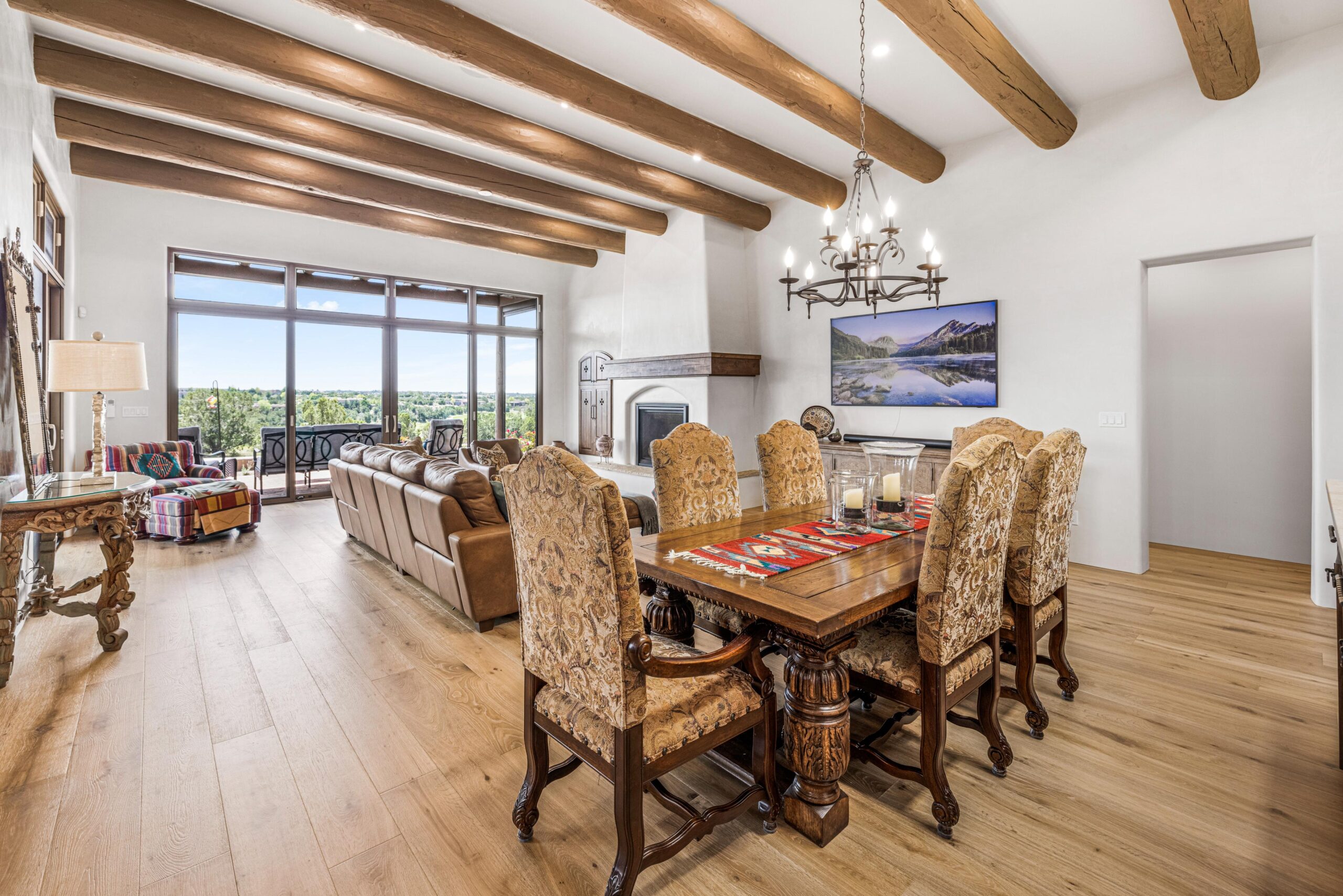 Elegant dining and living area with rustic wooden beams and large windows.