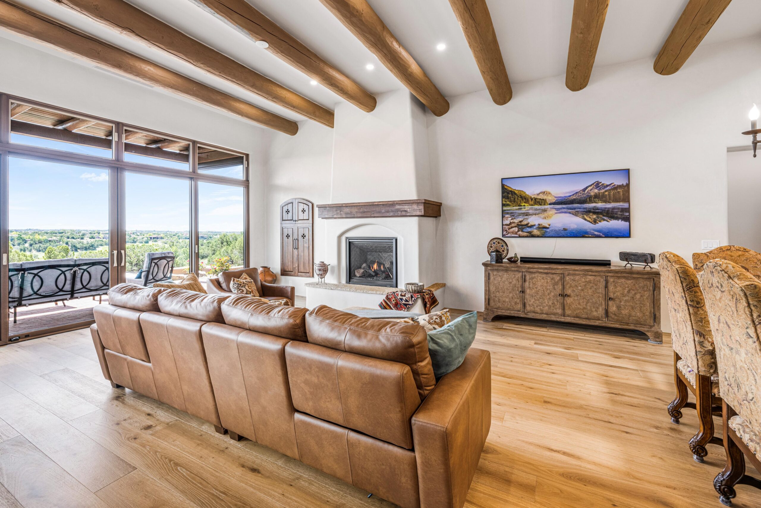 Spacious living room with leather sofas and a fireplace.