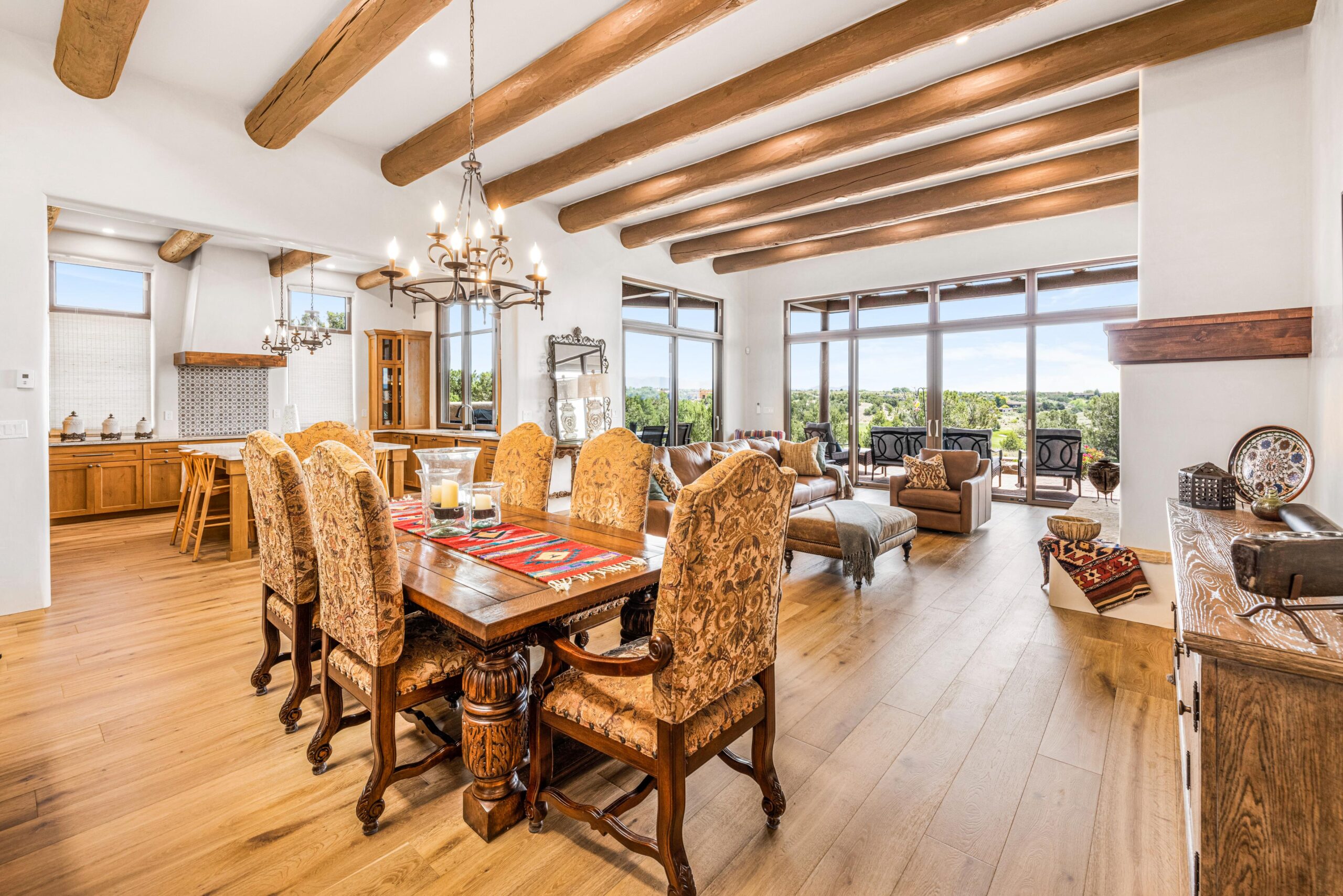 Elegant dining area with wooden beams and large windows overlooking a scenic view.