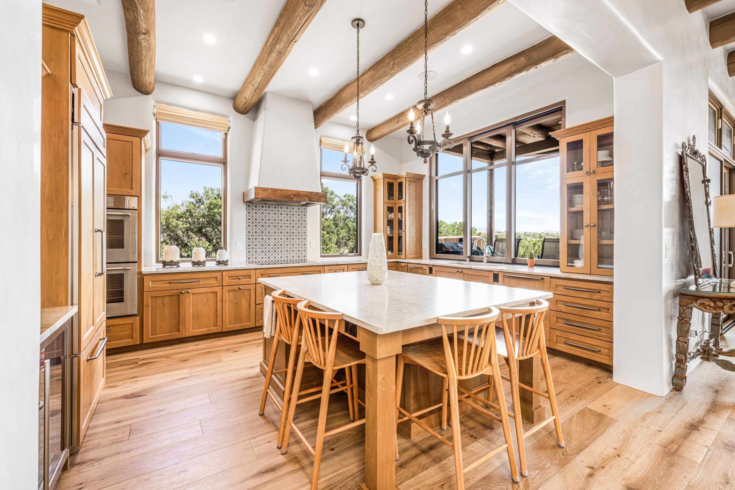 Bright kitchen with wooden beams and island seating.