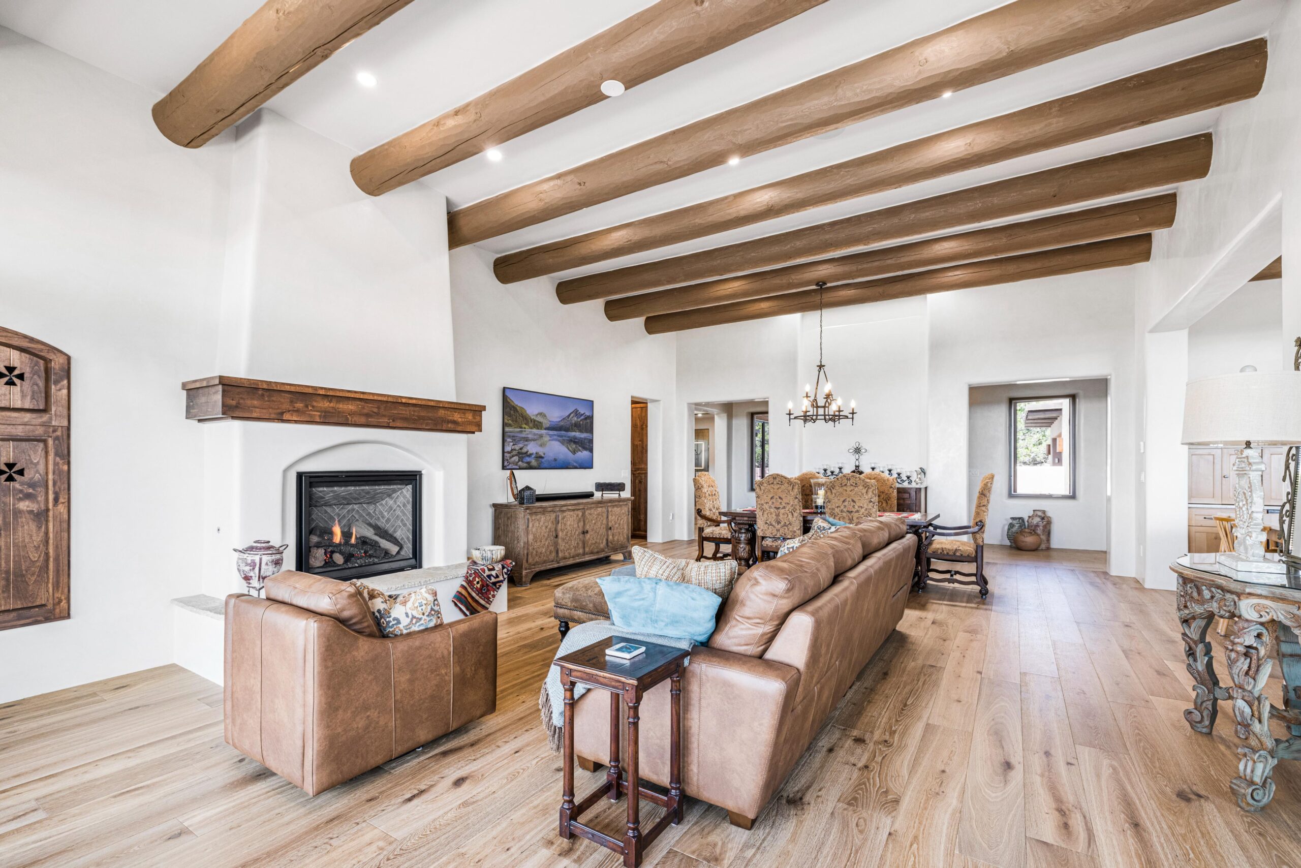 Spacious living room with wooden beams and cozy fireplace.