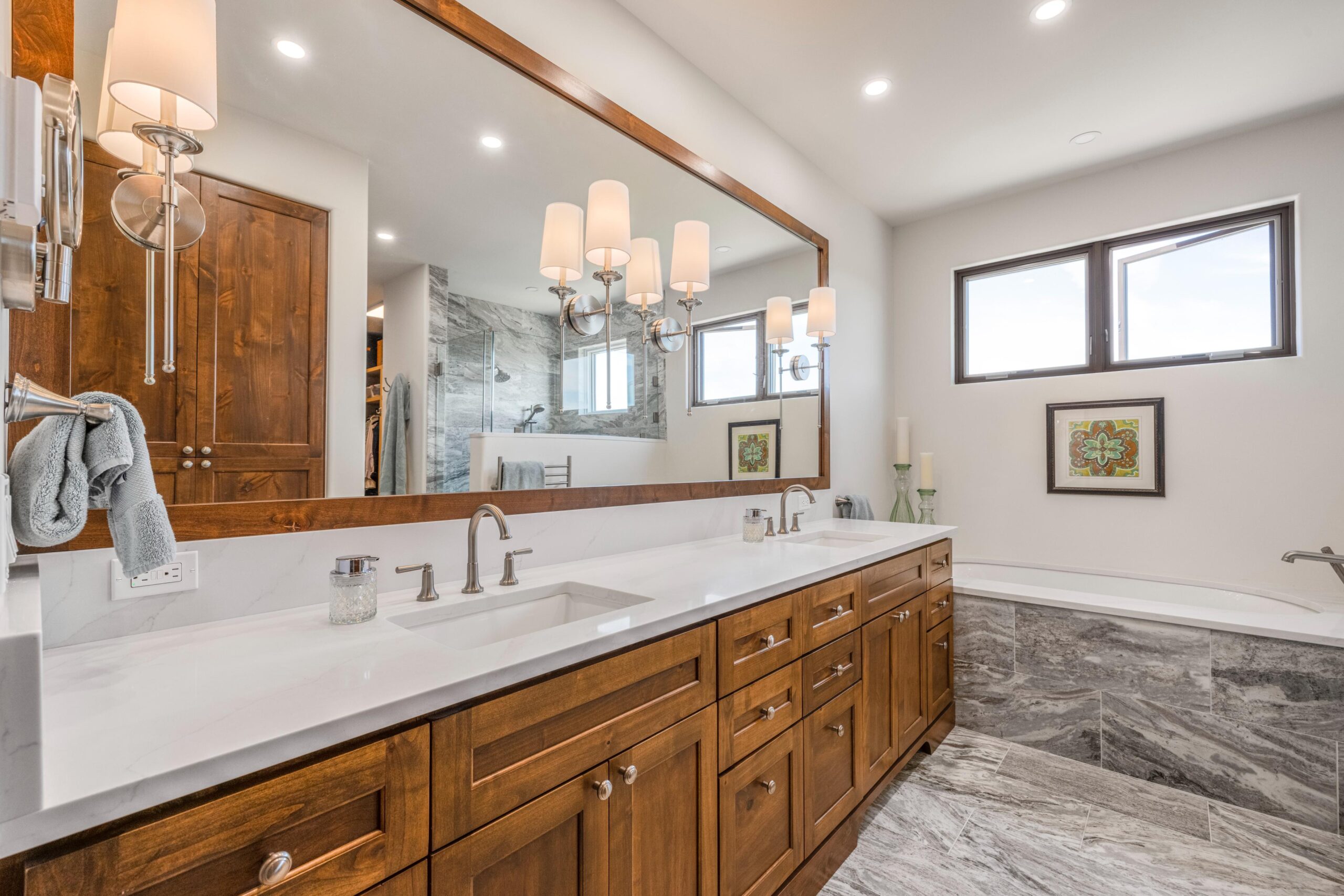 Spacious bathroom with wooden cabinetry and large mirror.