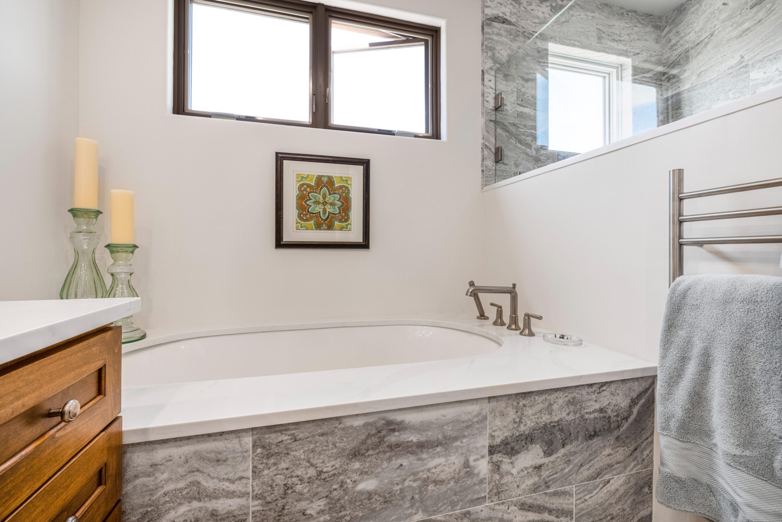 Modern bathroom with a stone bathtub and framed artwork.