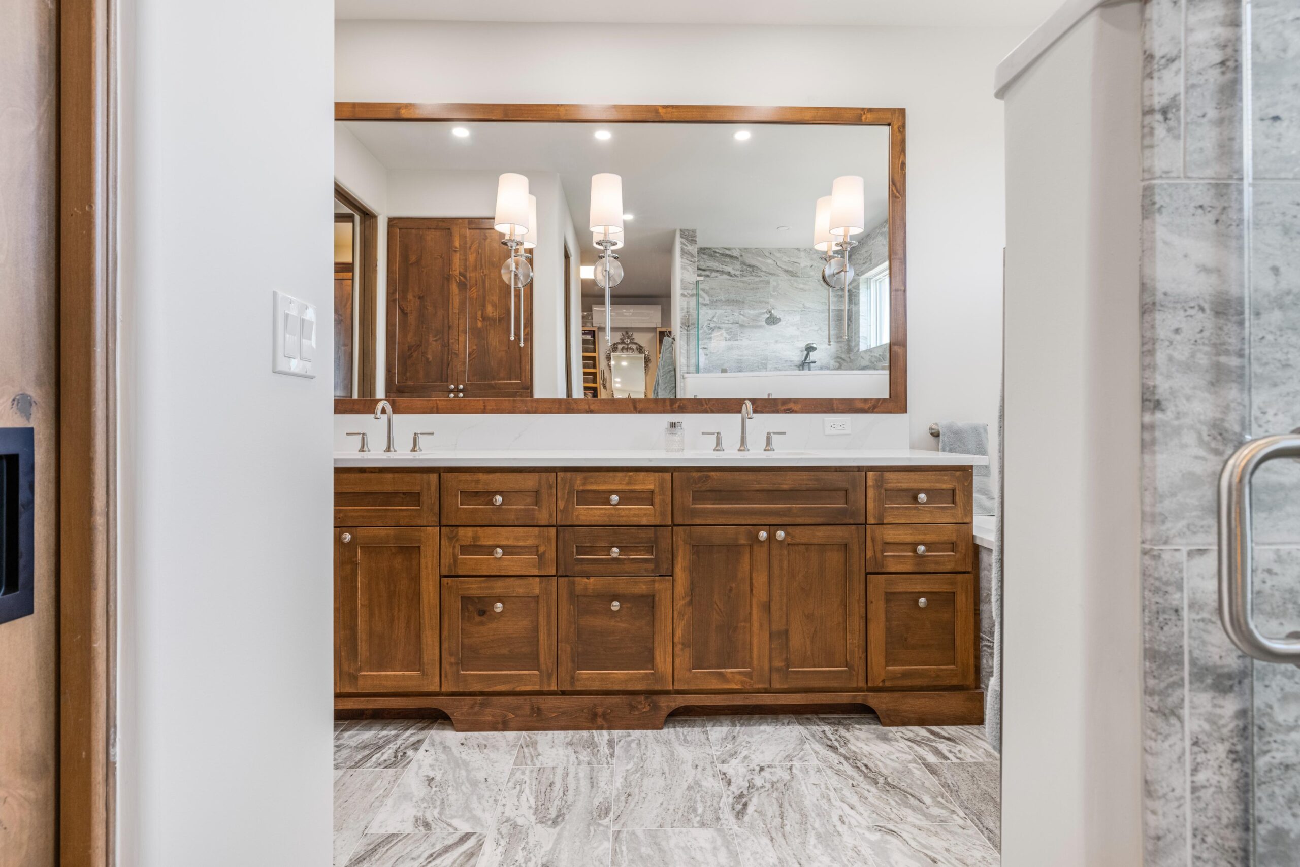 Spacious bathroom vanity with wooden cabinets and a large mirror.