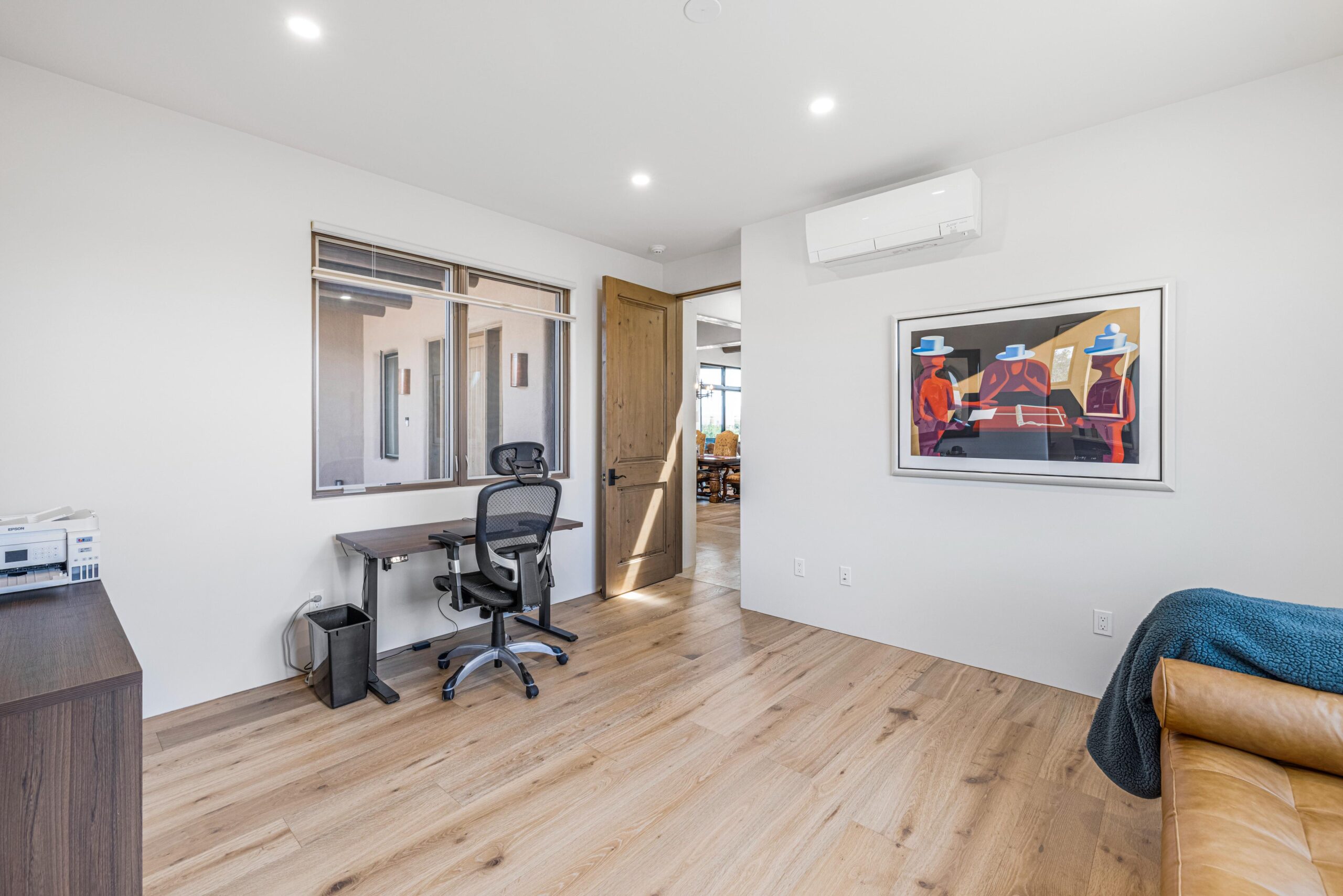 Modern home office with ergonomic chair and cityscape window decal.