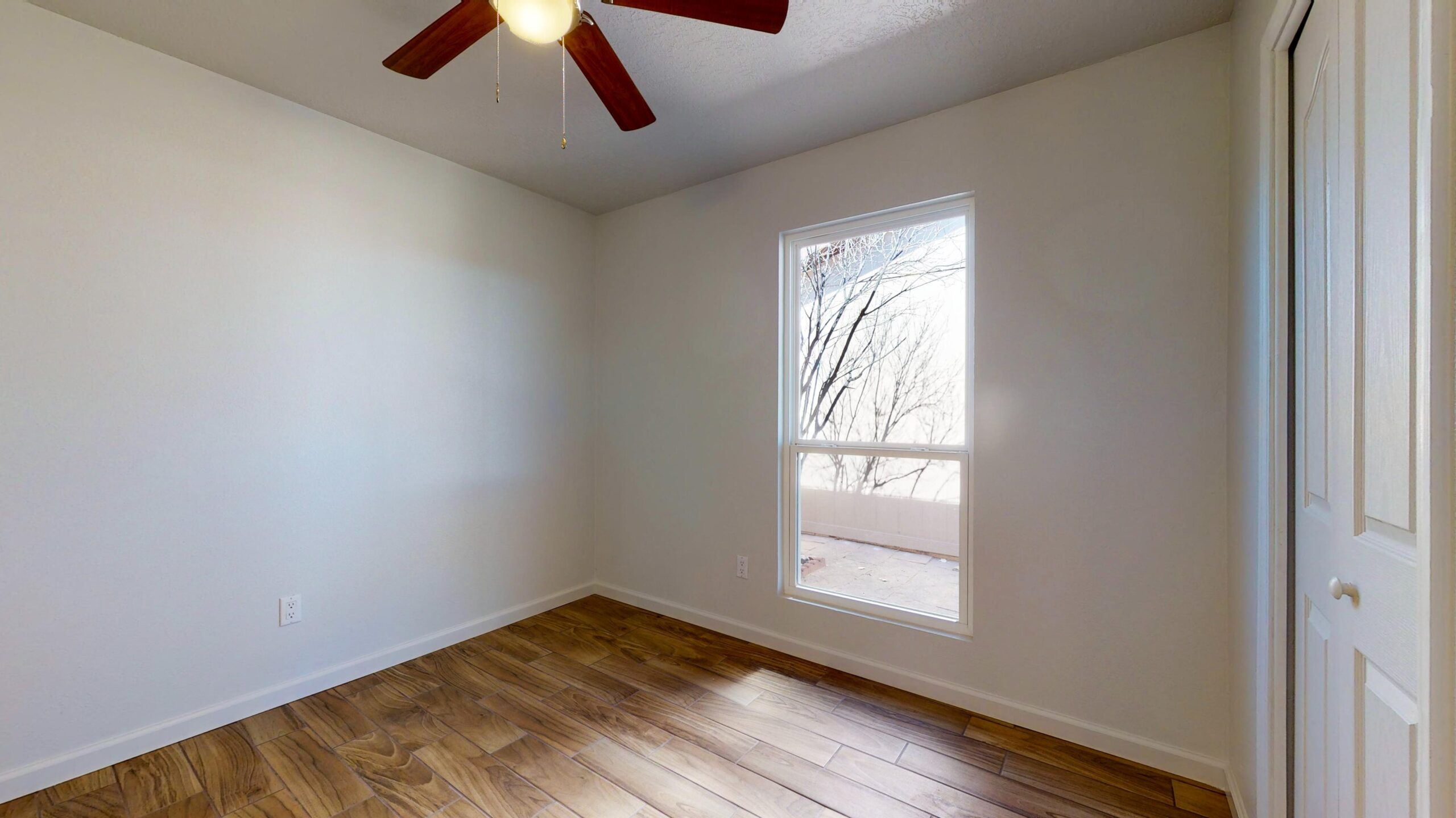 Empty room with wooden floor and window.