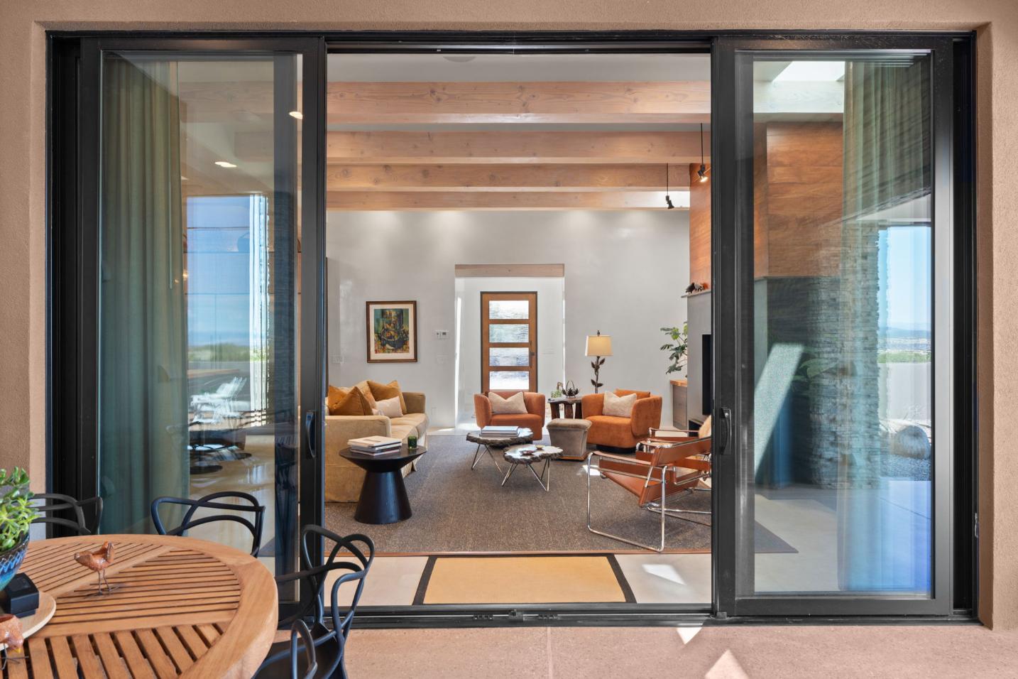 Modern living room with leather chairs and sliding glass doors.