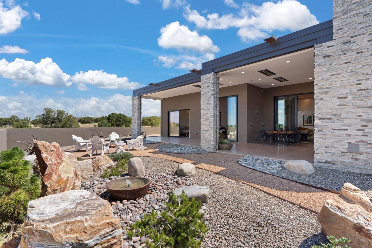 Modern house with a spacious outdoor patio and desert landscaping.