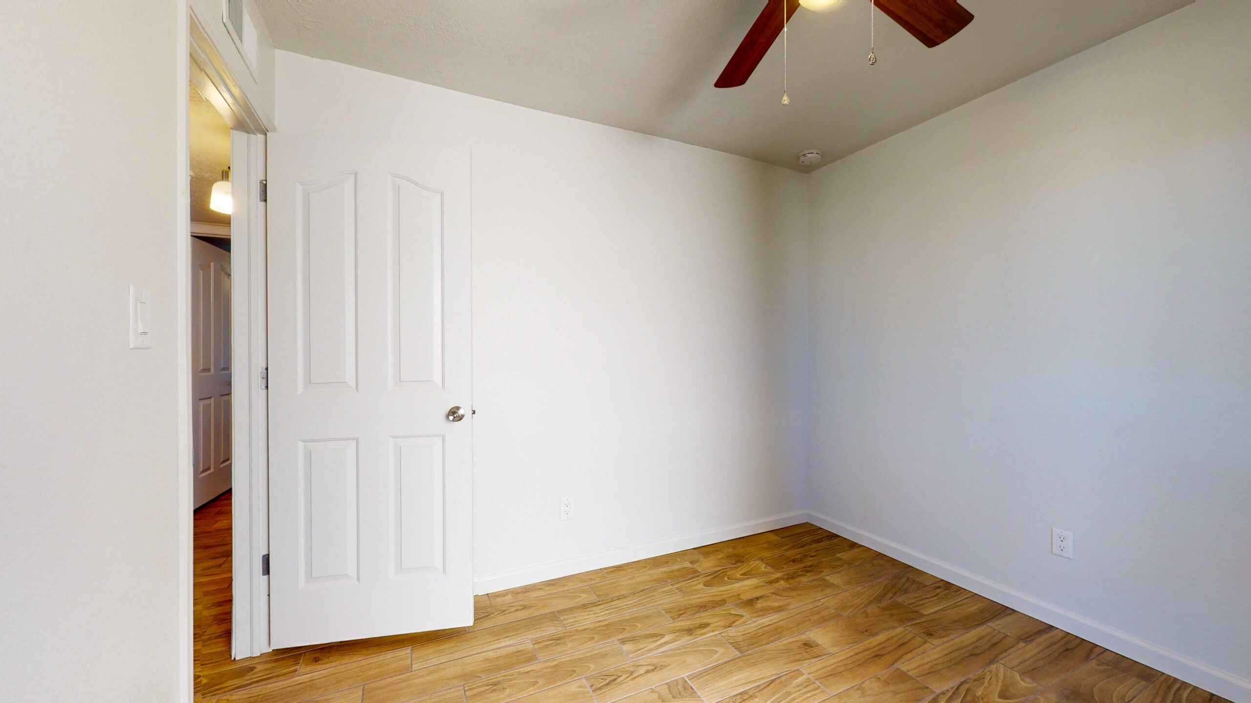 Empty room with wooden floor and white walls.