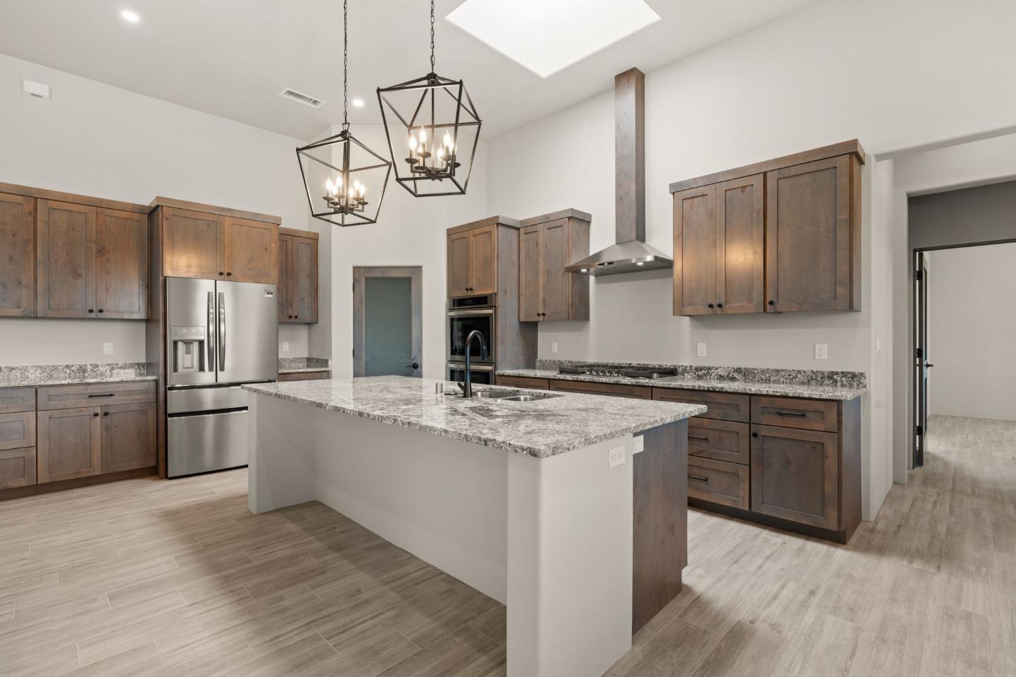 Modern kitchen with granite countertops and wooden cabinets.