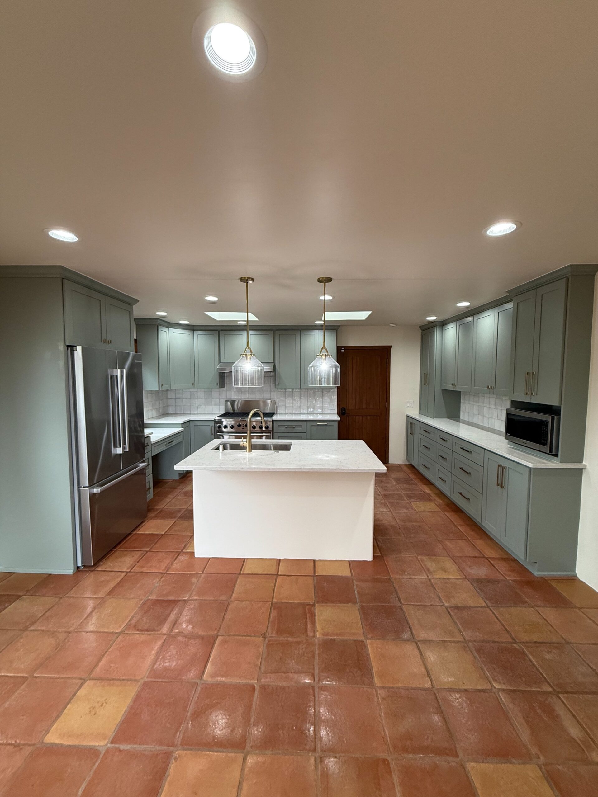 Modern kitchen with a central island and stainless steel appliances.