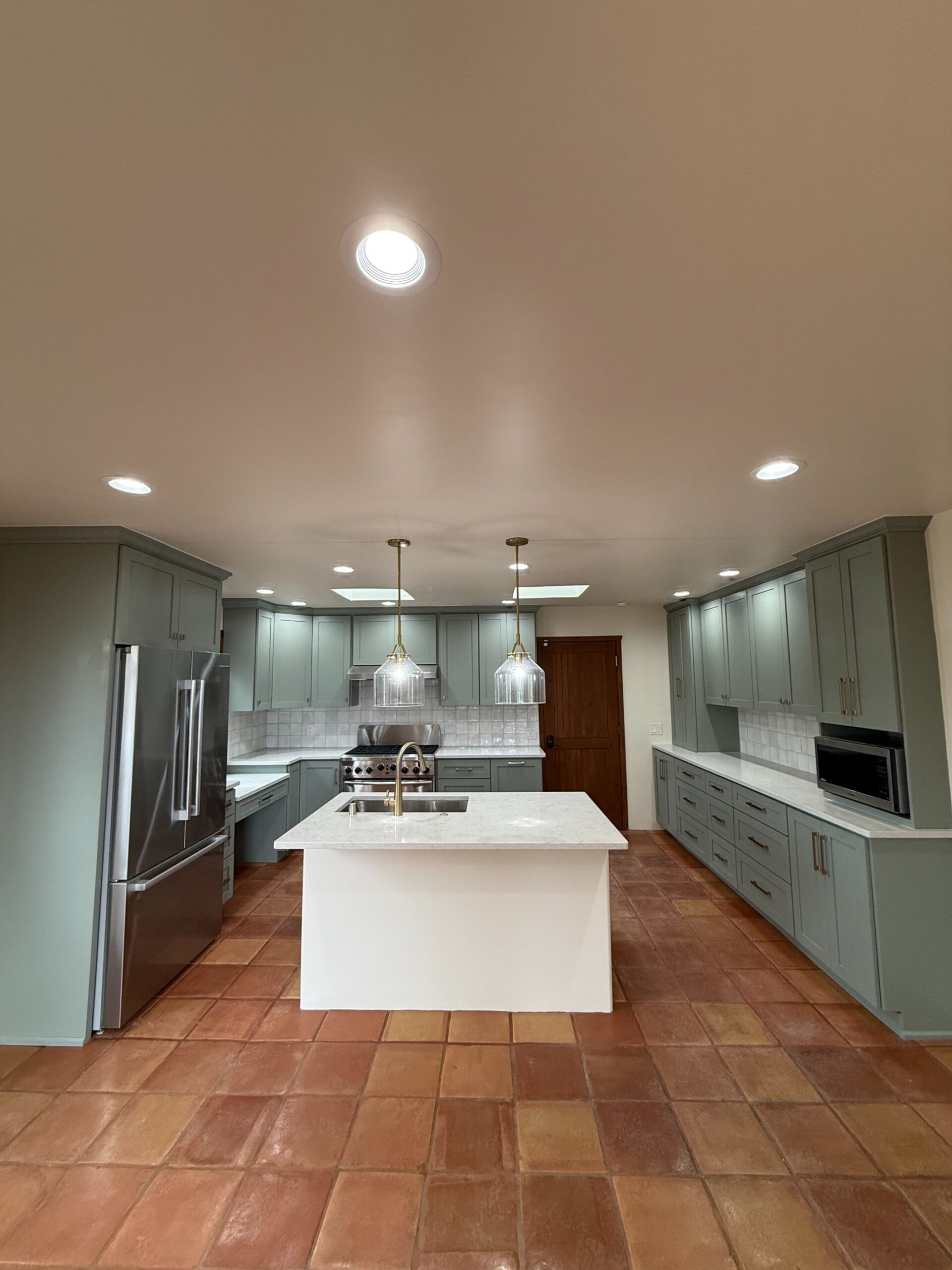 Modern kitchen with a central island and gray cabinets.