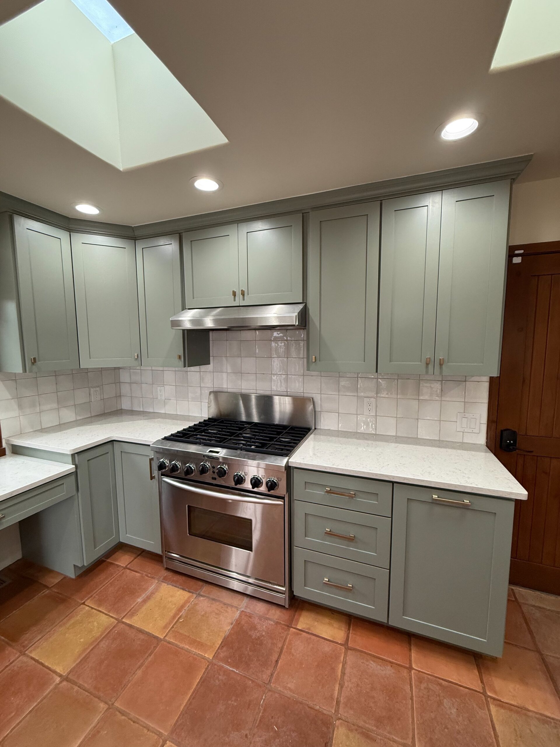 Modern kitchen with gray cabinets and stainless steel stove.