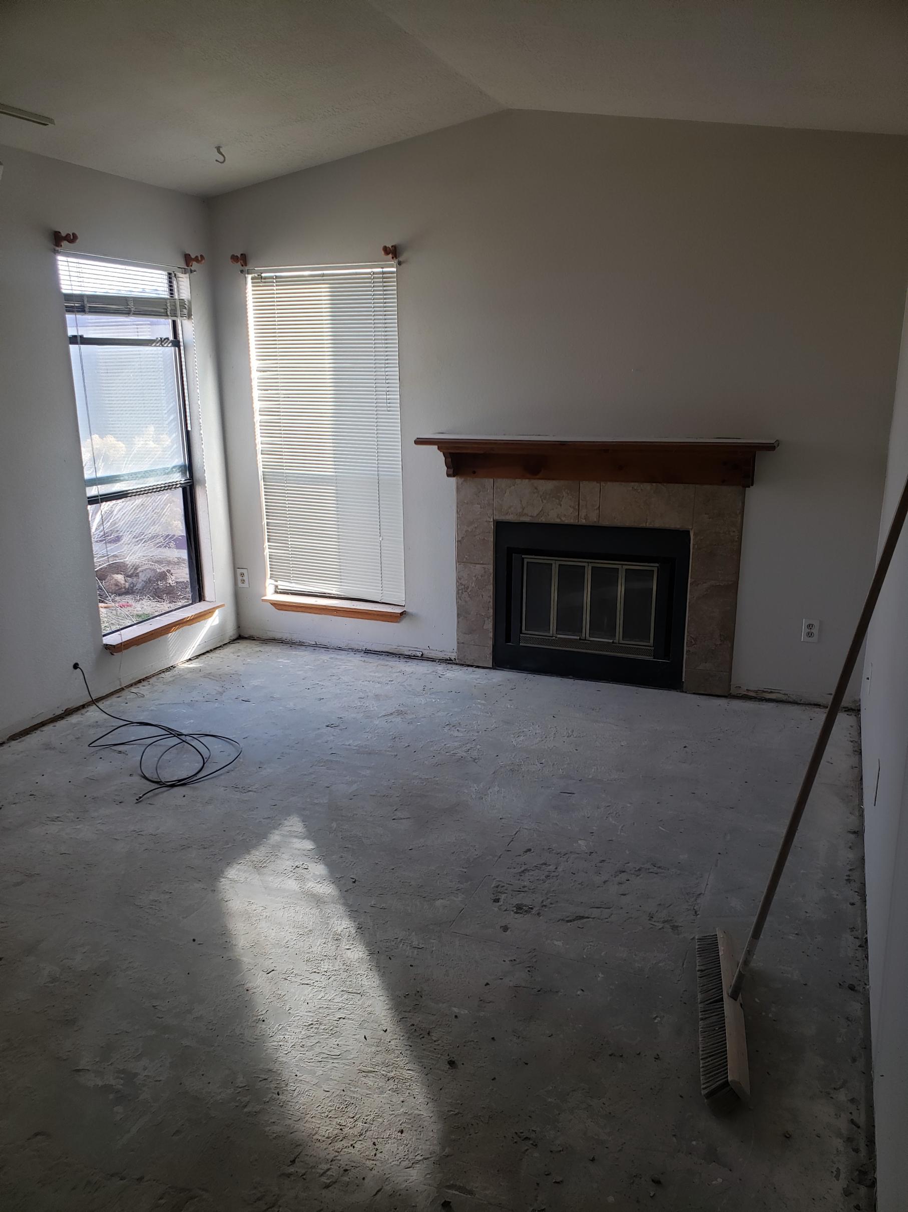 Empty living room with fireplace and sliding glass door.