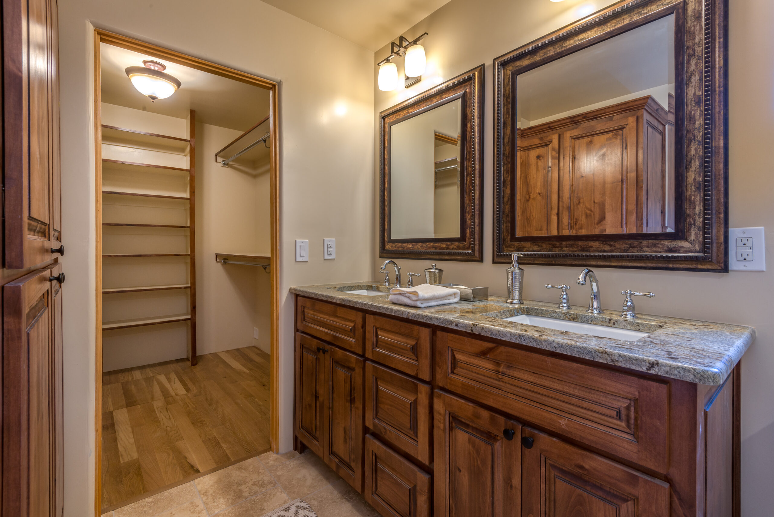 Rustic bathroom with wooden cabinetry and a walk-in closet.