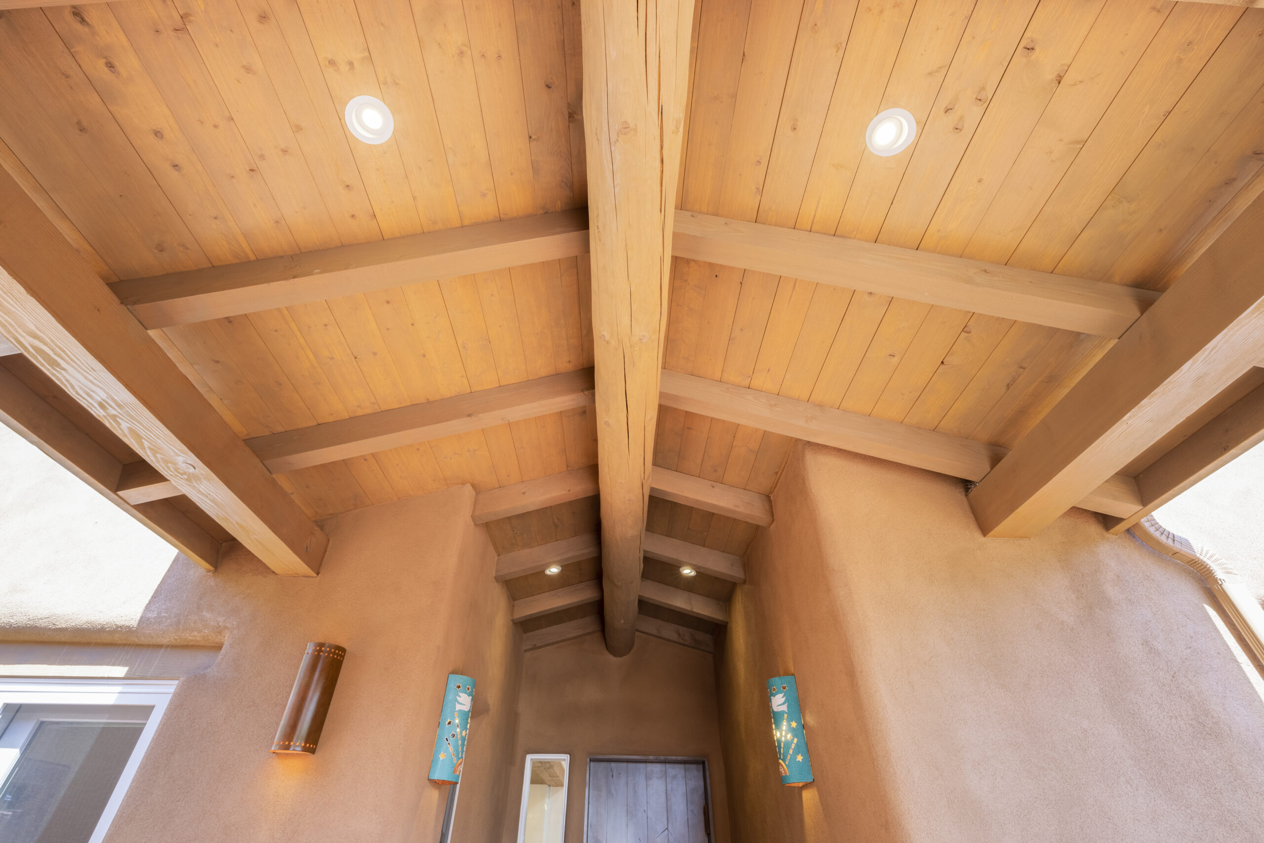 Warm wood-beamed ceiling in a cozy room with soft lighting.