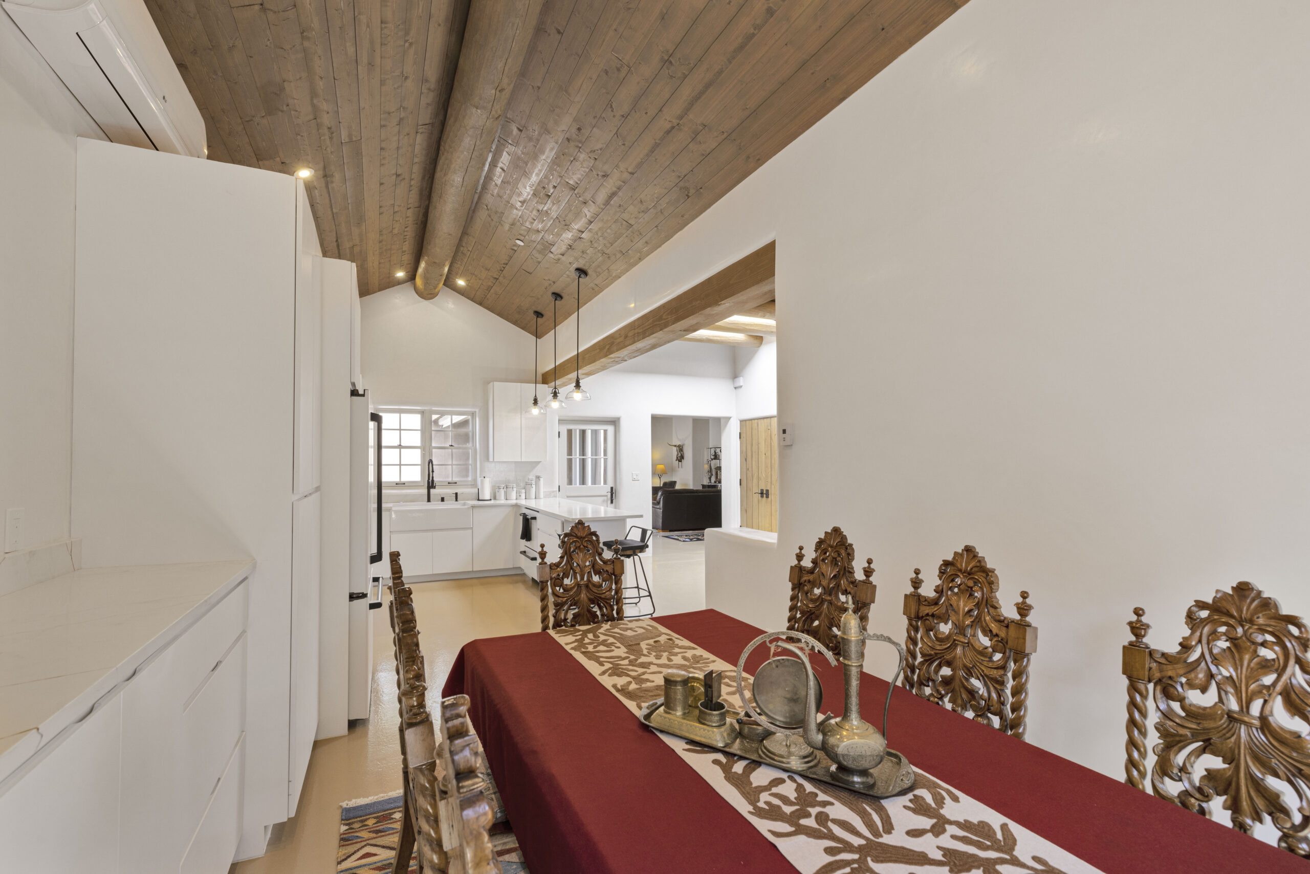 Spacious dining area with ornate chairs and wooden ceiling beams.