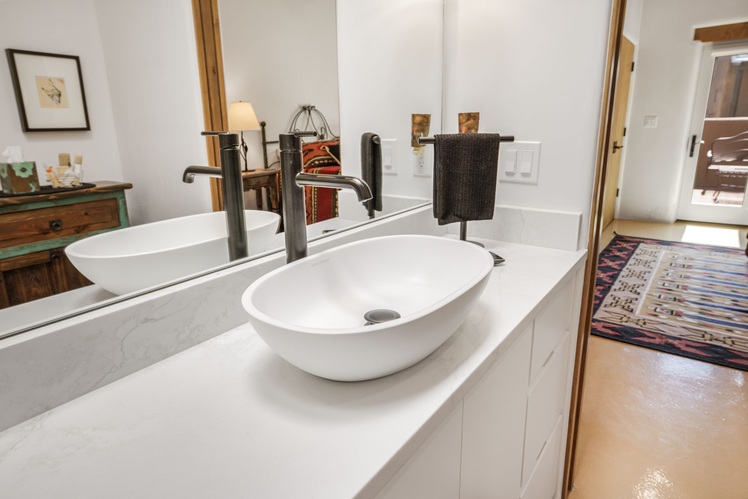 Modern white bathroom sink with sleek black faucet and mirror.
