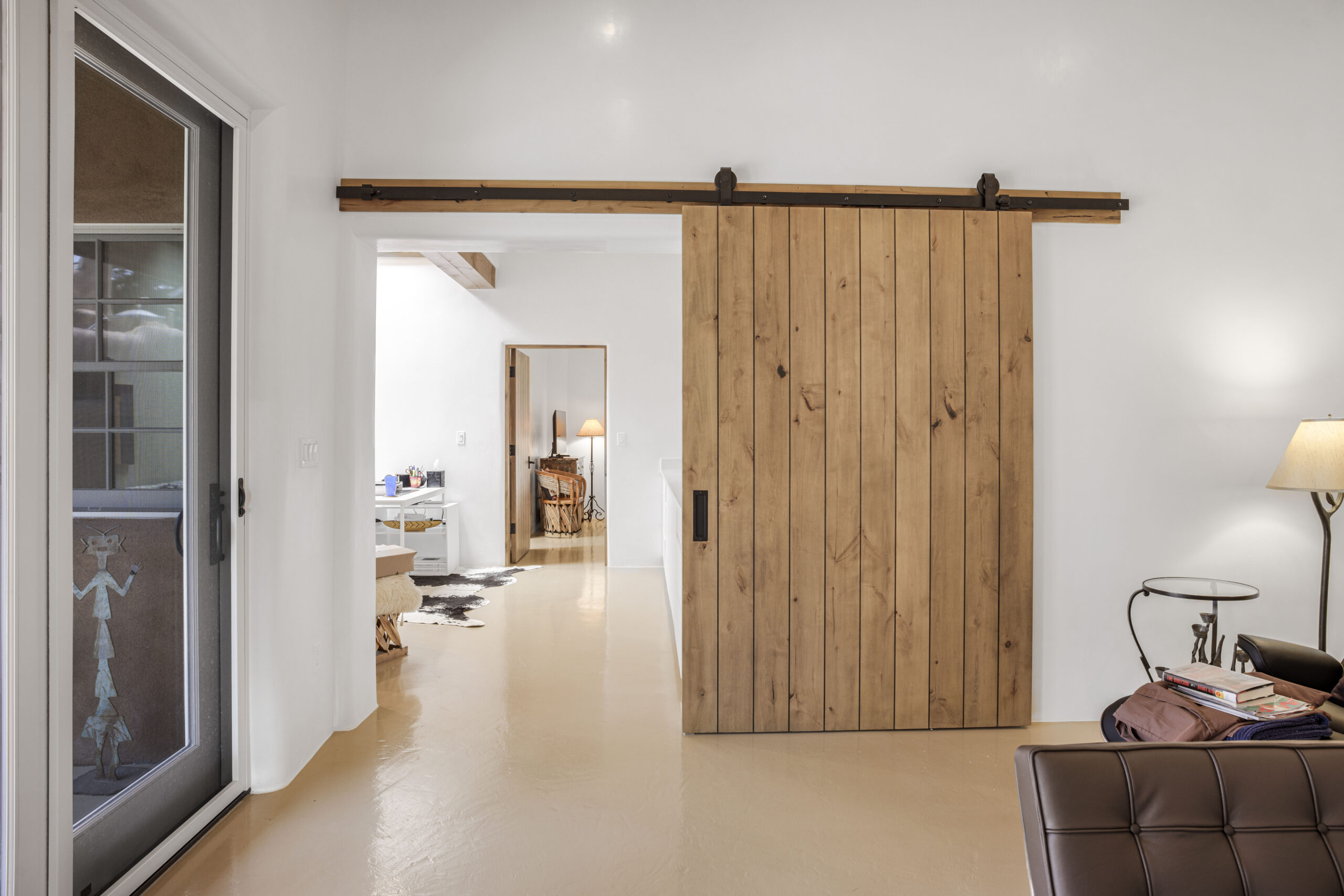 Modern interior with a sliding wooden barn door separating rooms.